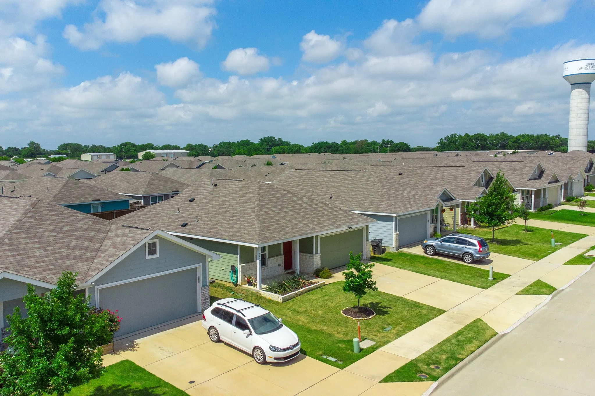 Residential community featuring a uniform architectural style with shingled roofs and attached garages