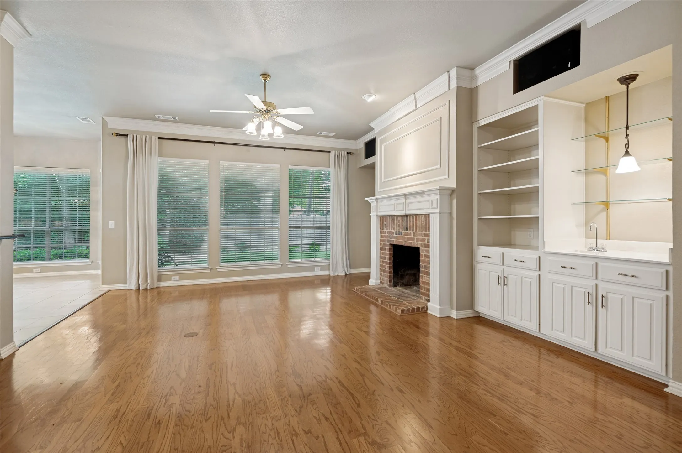 The wet bar is ready for entertaining and the wall of windows overlooks the lushly landscaped backyard.