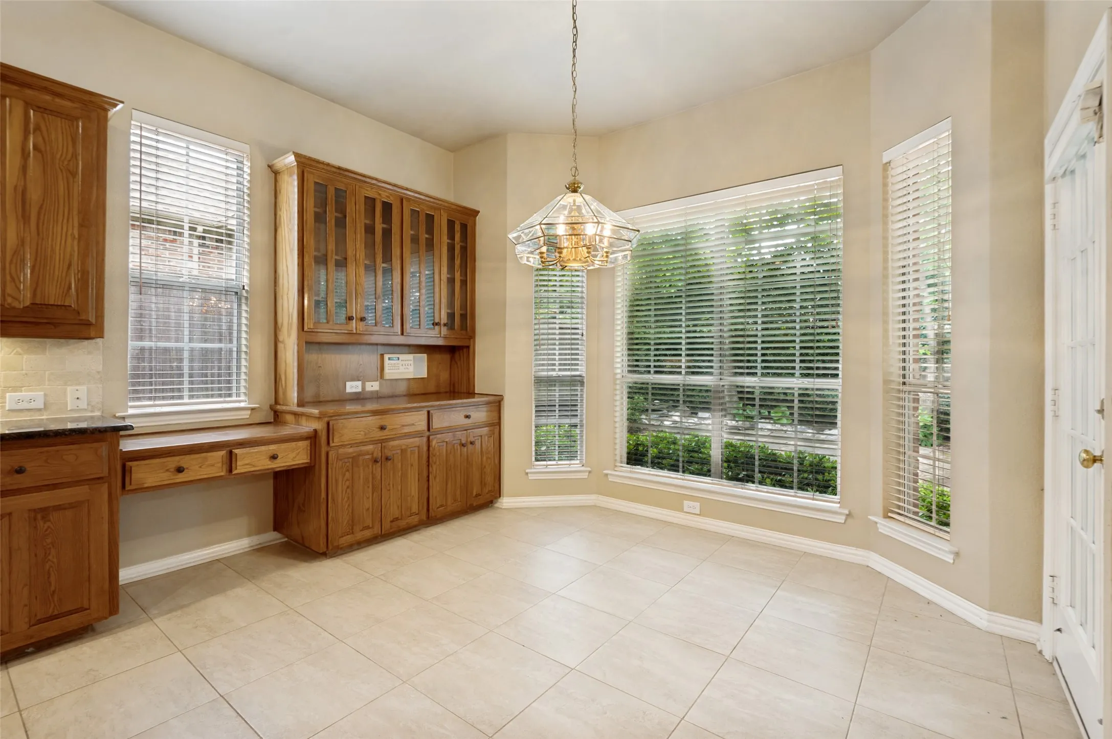 Overlooking the backyard the dining has a custom hutch and desk and opens to the patio.