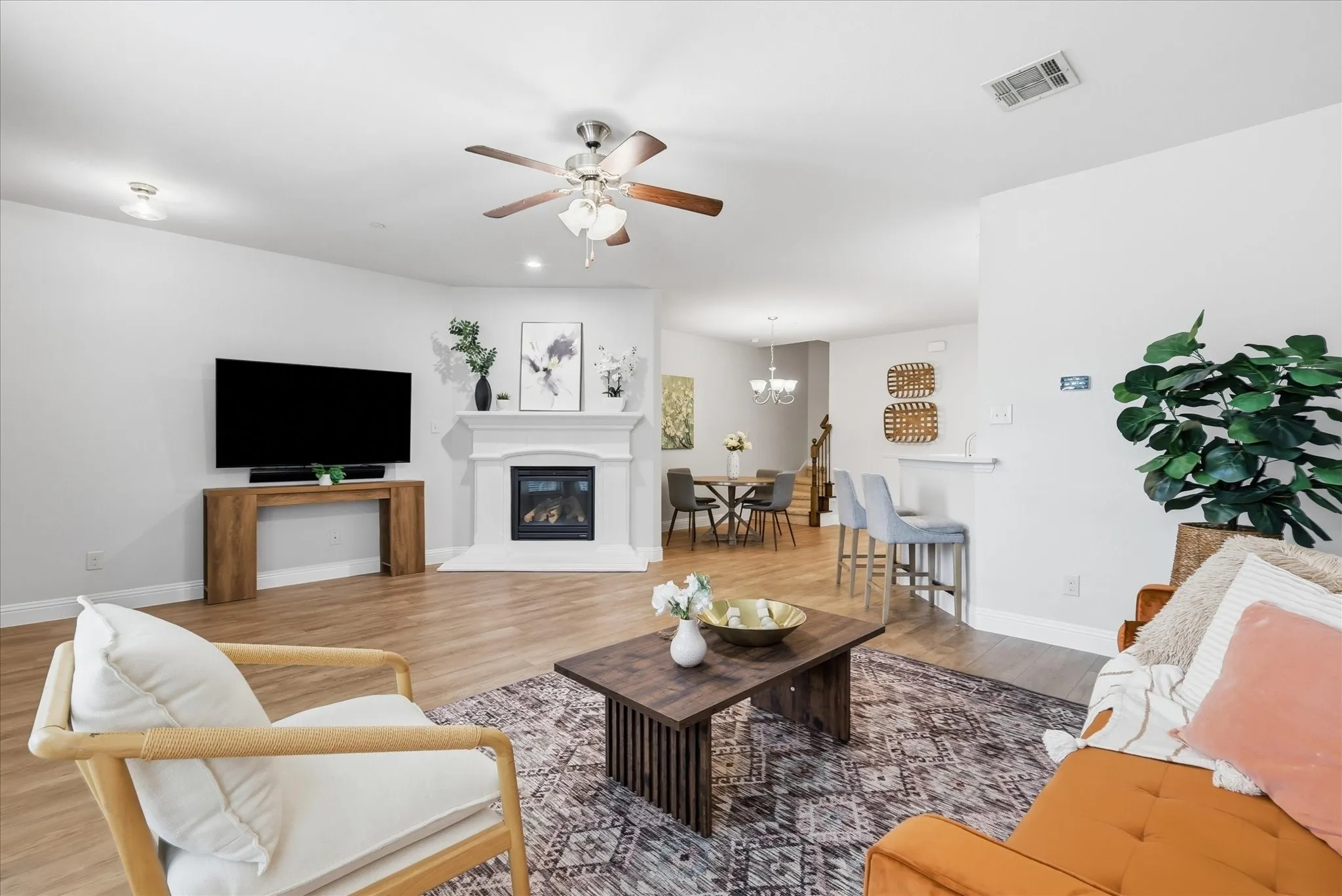 Spacious living area featuring a built-in fireplace with a mantle, wood-finish flooring, and recessed lighting