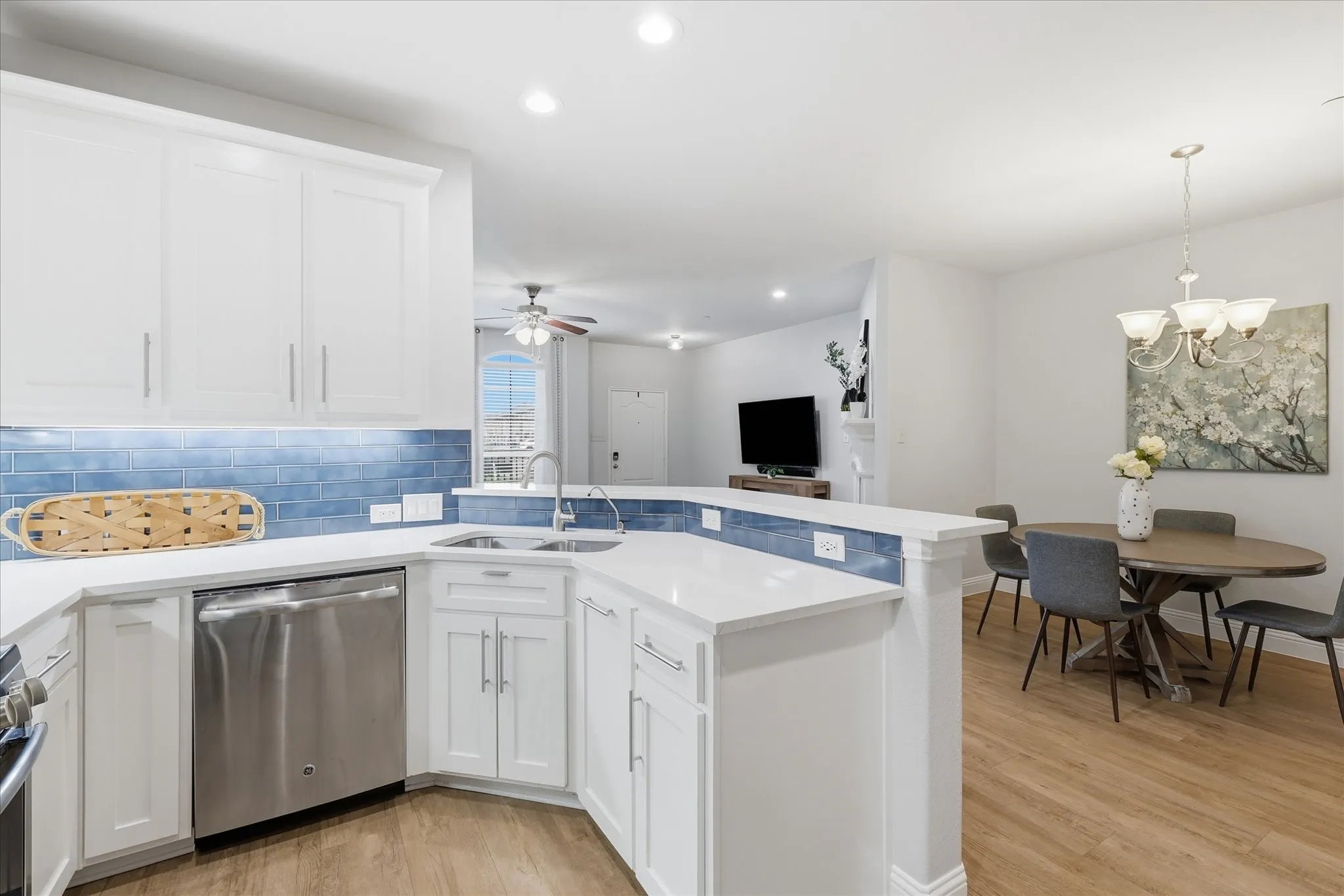 Kitchen featuring white shaker-style cabinetry, stainless steel appliances, and light-tone countertops