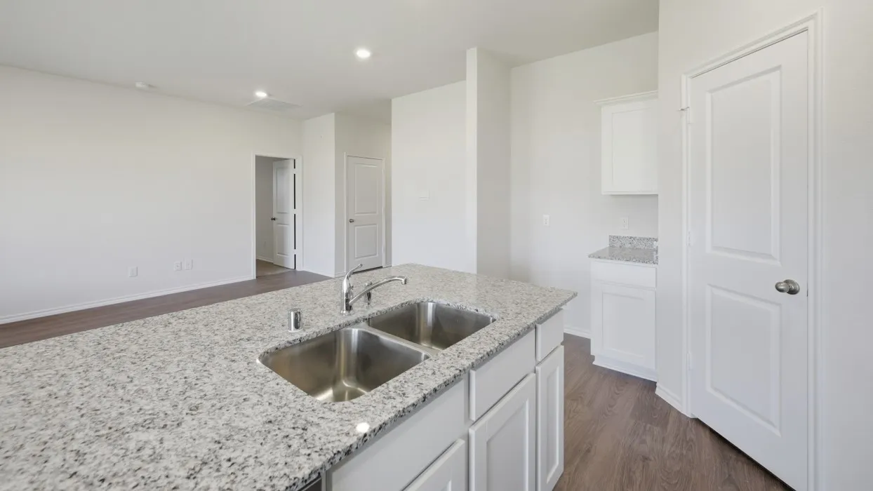 Kitchen island featuring a dual stainless steel sink and granite-style countertop