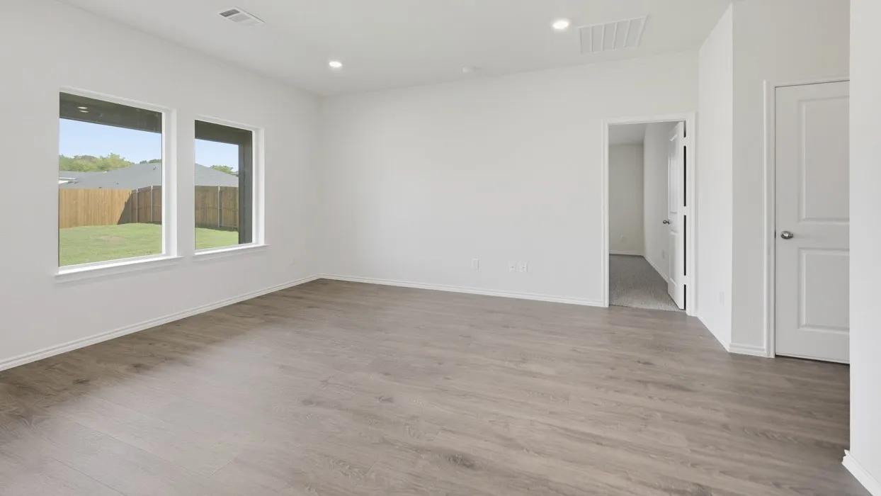Spacious room featuring wood-finish flooring, white walls, and recessed lighting