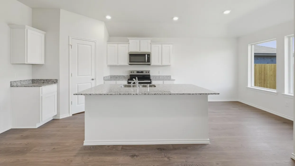 Central kitchen island with an integrated sink and light-colored speckled countertops