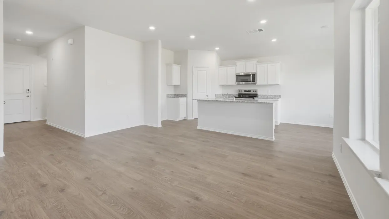 Open-concept living area featuring wood-finish flooring, recessed lighting, and ample natural light