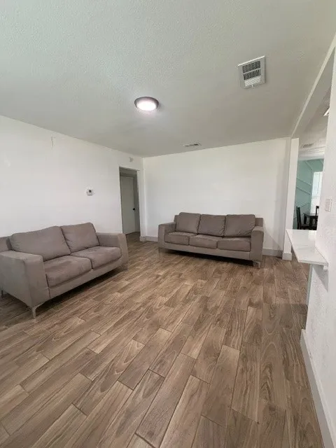 Spacious interior featuring wood-finish flooring, recessed lighting, and bright white walls
