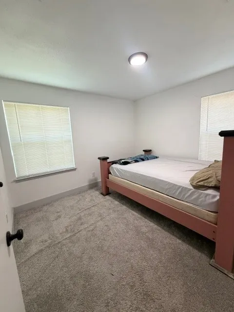 Bedroom with gray carpeting and white walls