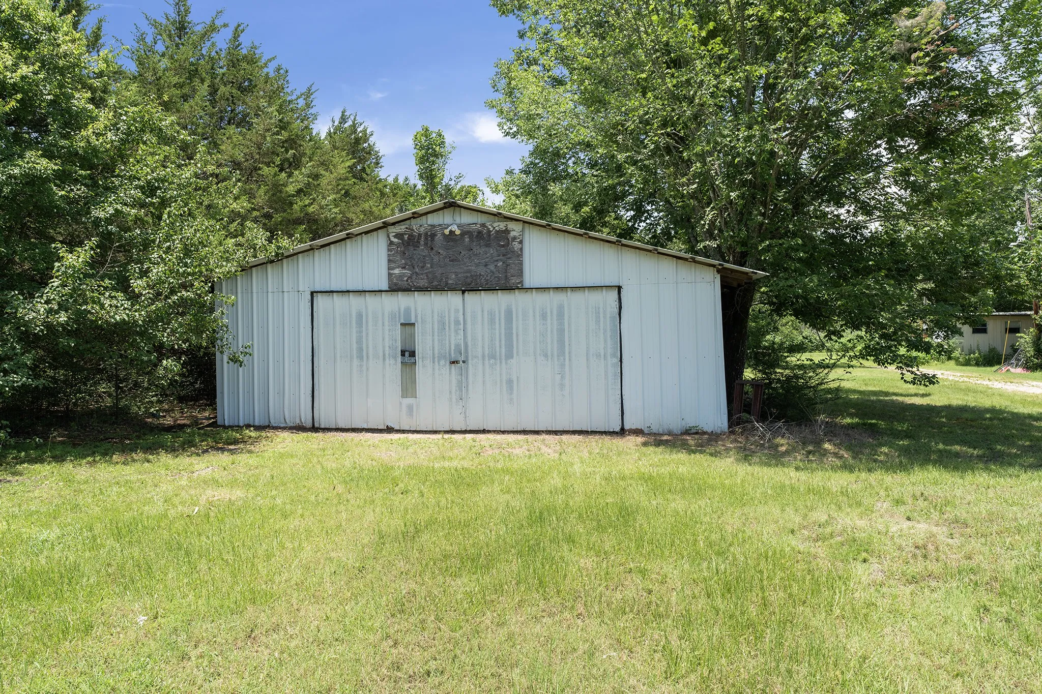 Metal-sided barn featuring a pitched roof and large double doors