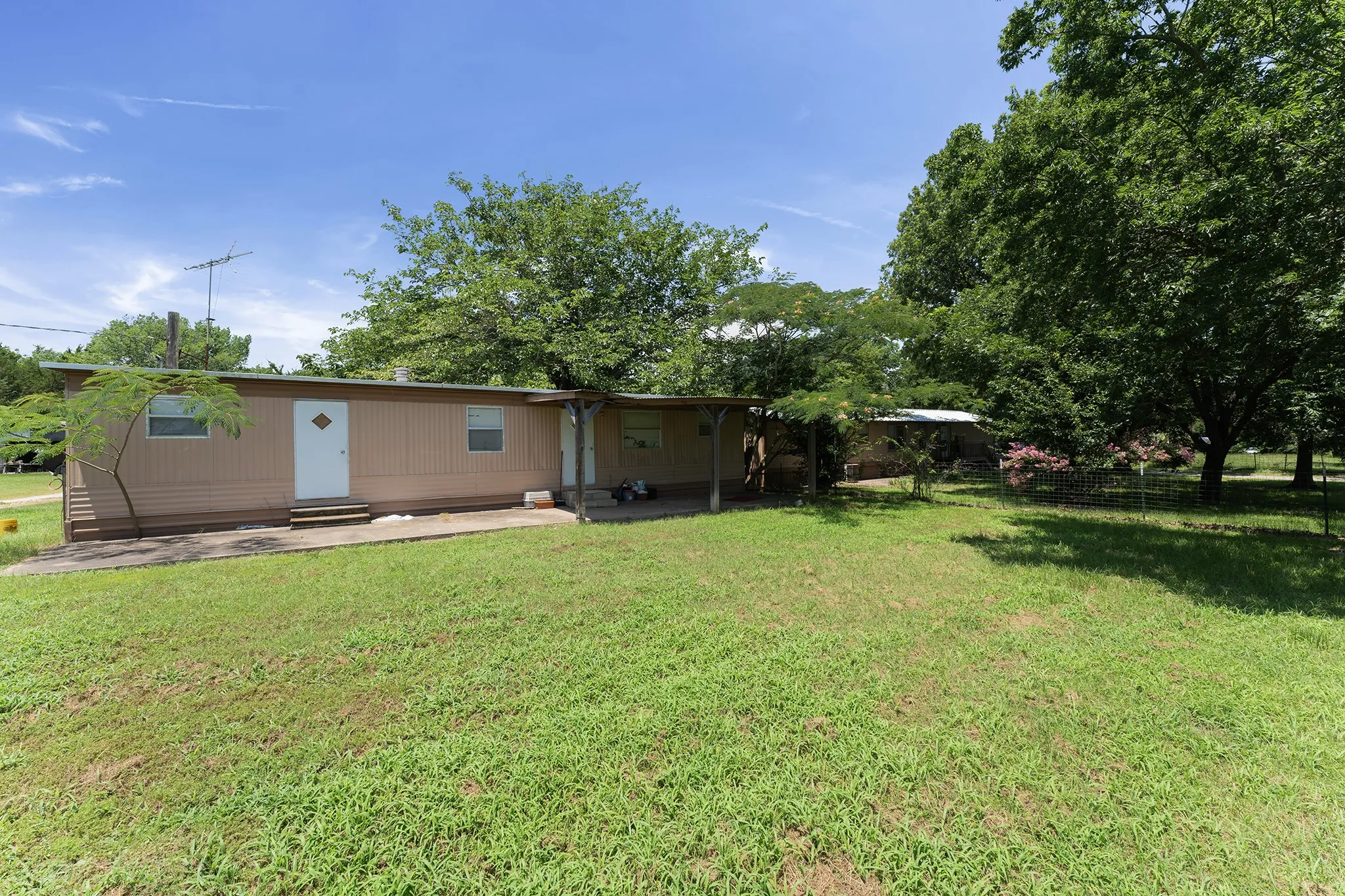 Exterior with beige siding, white diamond-paneled door, and two rectangular windows