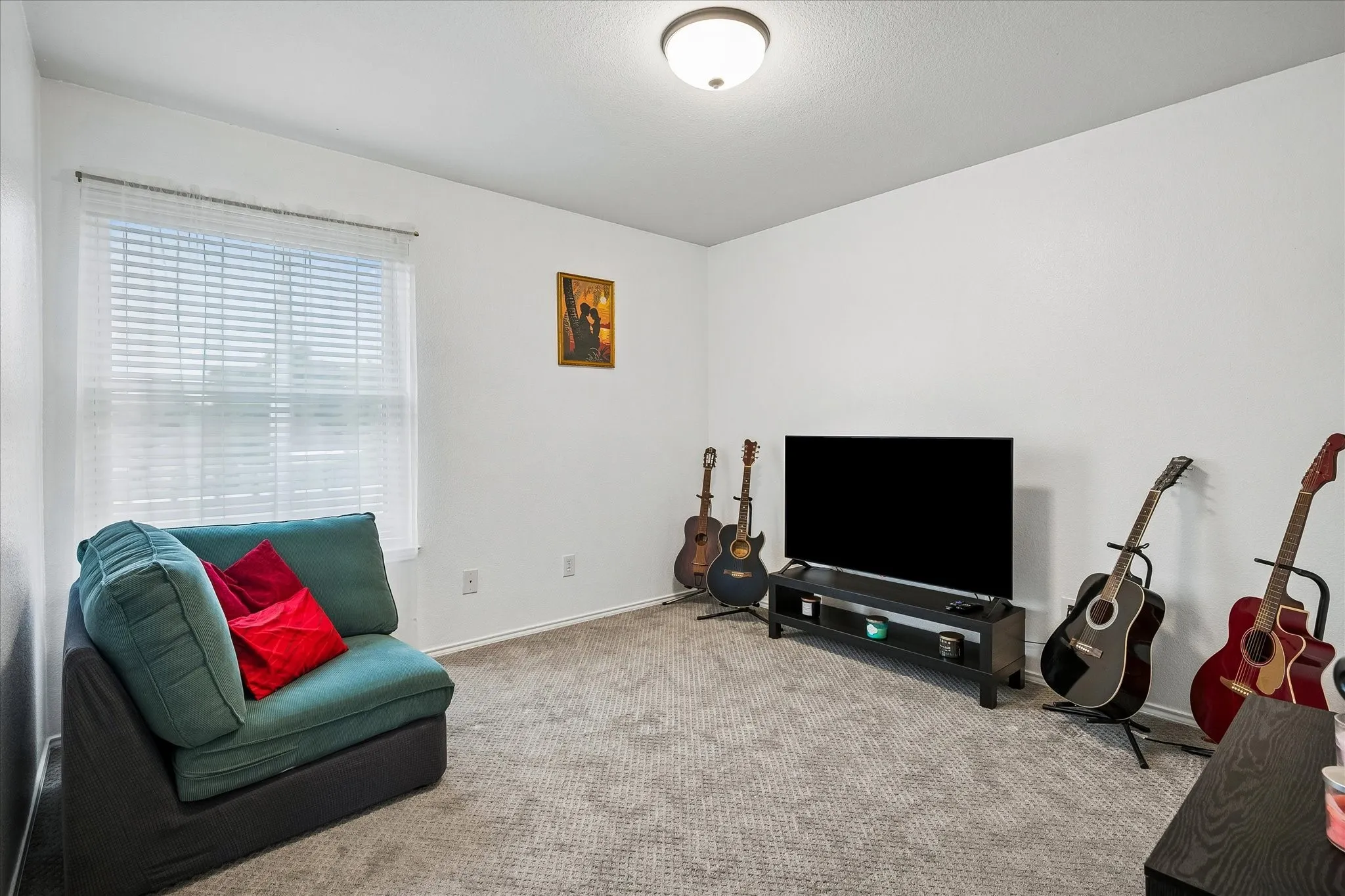 Carpeted flooring, white walls, and a window with blinds