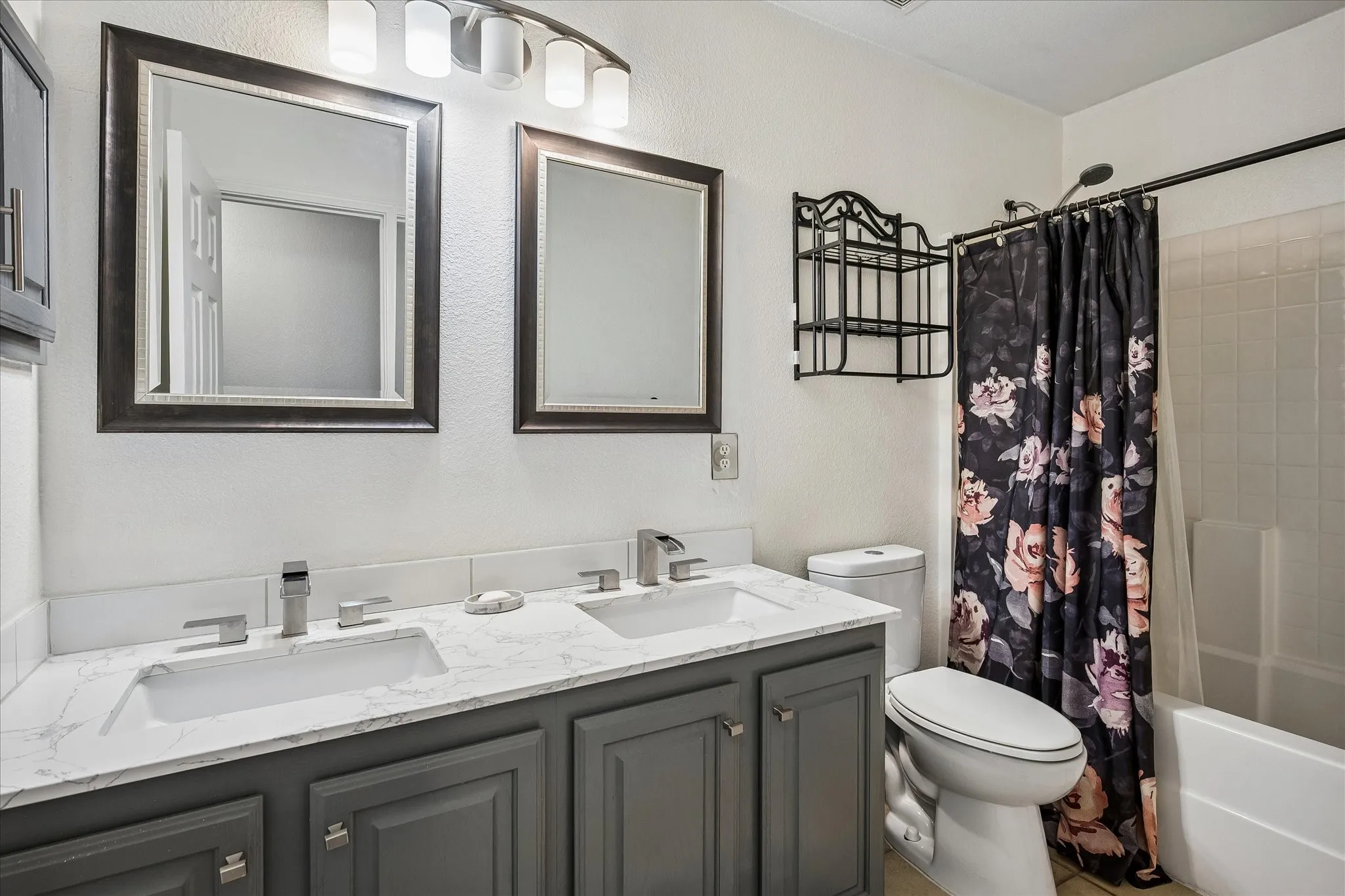 Dual vanity with white countertop, chrome fixtures, and shaker-style cabinetry