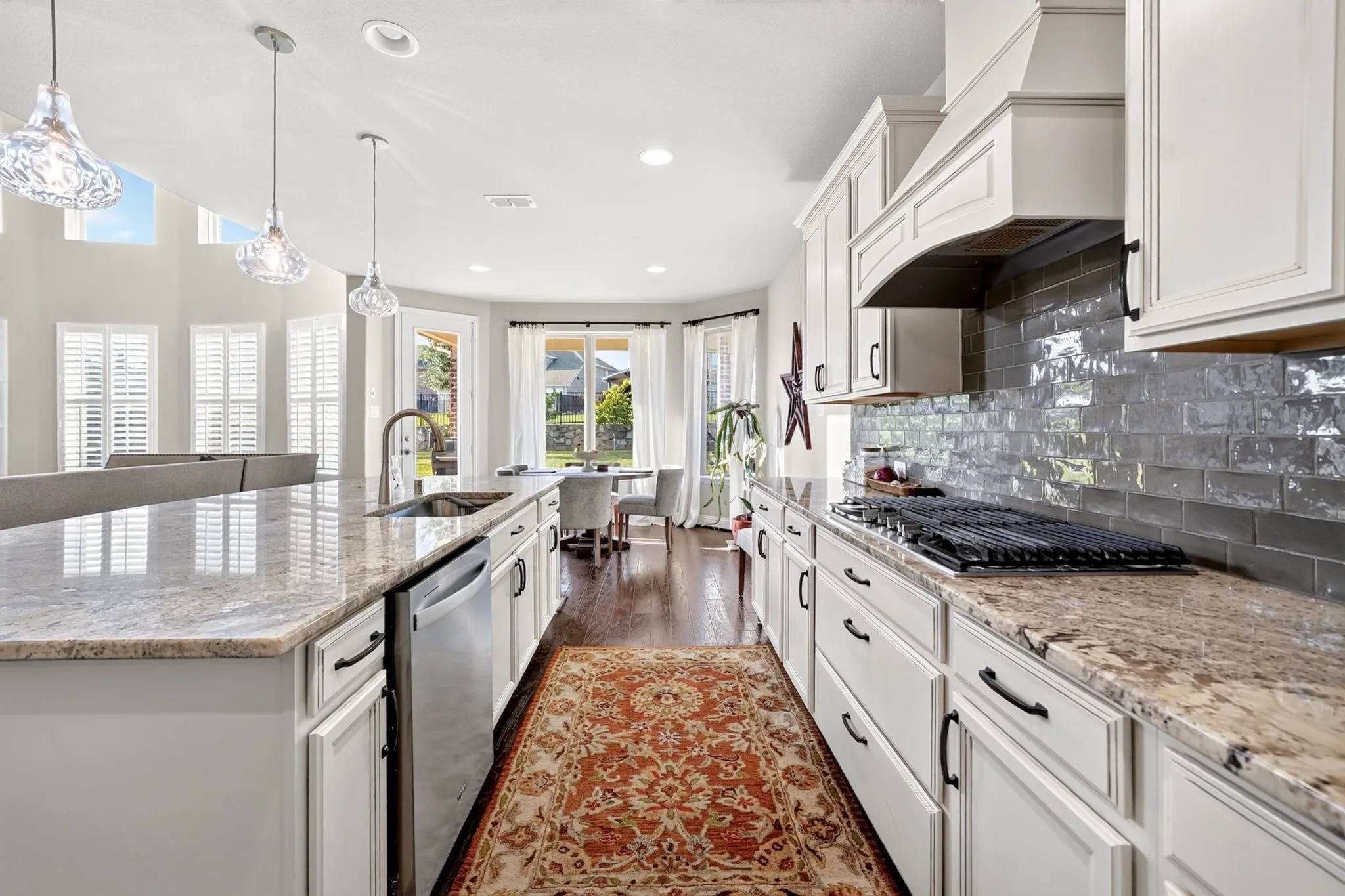 Spacious kitchen featuring light-toned cabinetry, a built-in gas range, and a subway tile backsplash