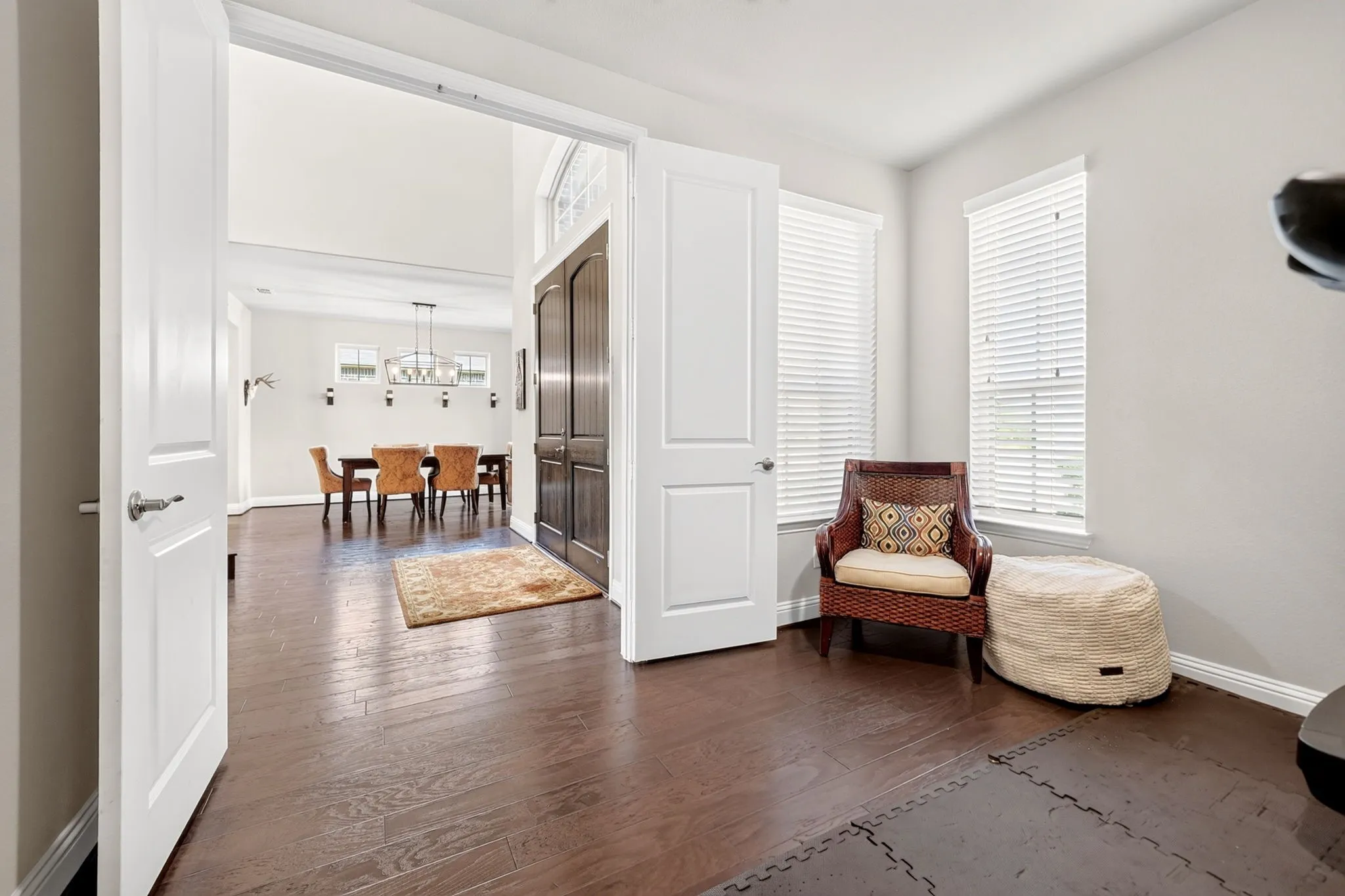 Foyer with dark wood-finish flooring, tall ceilings, and a dark wood double-door entry