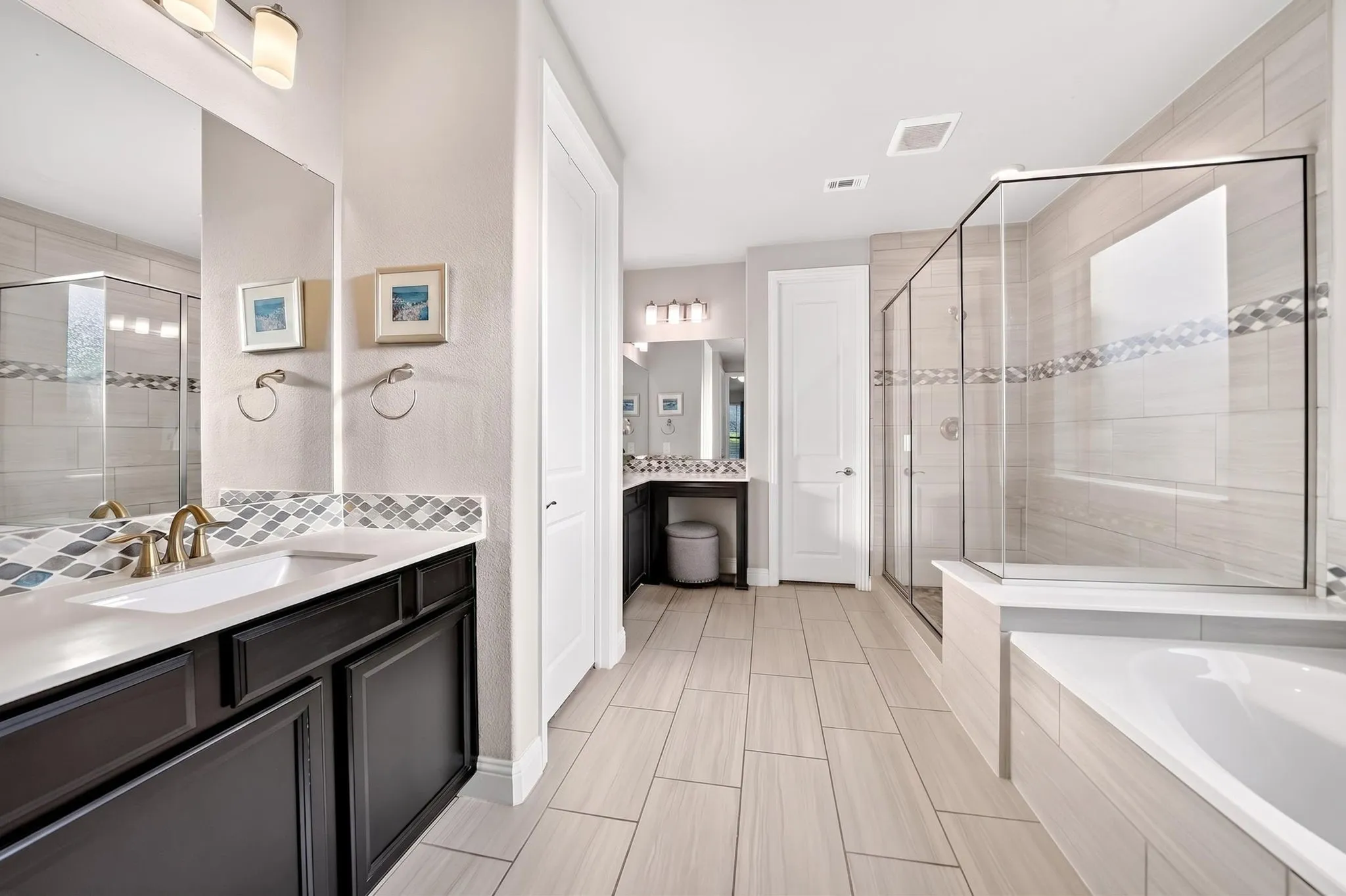 Spacious bathroom with light-toned plank-style flooring