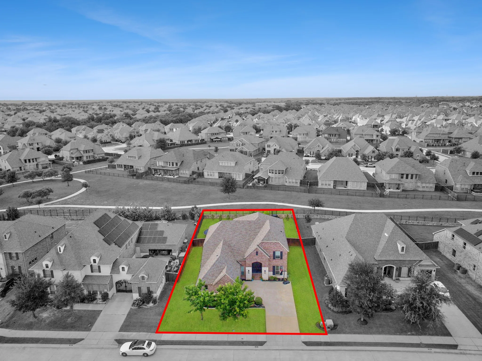 Brick facade residence with a gabled roofline, manicured lawn, and mature front yard tree