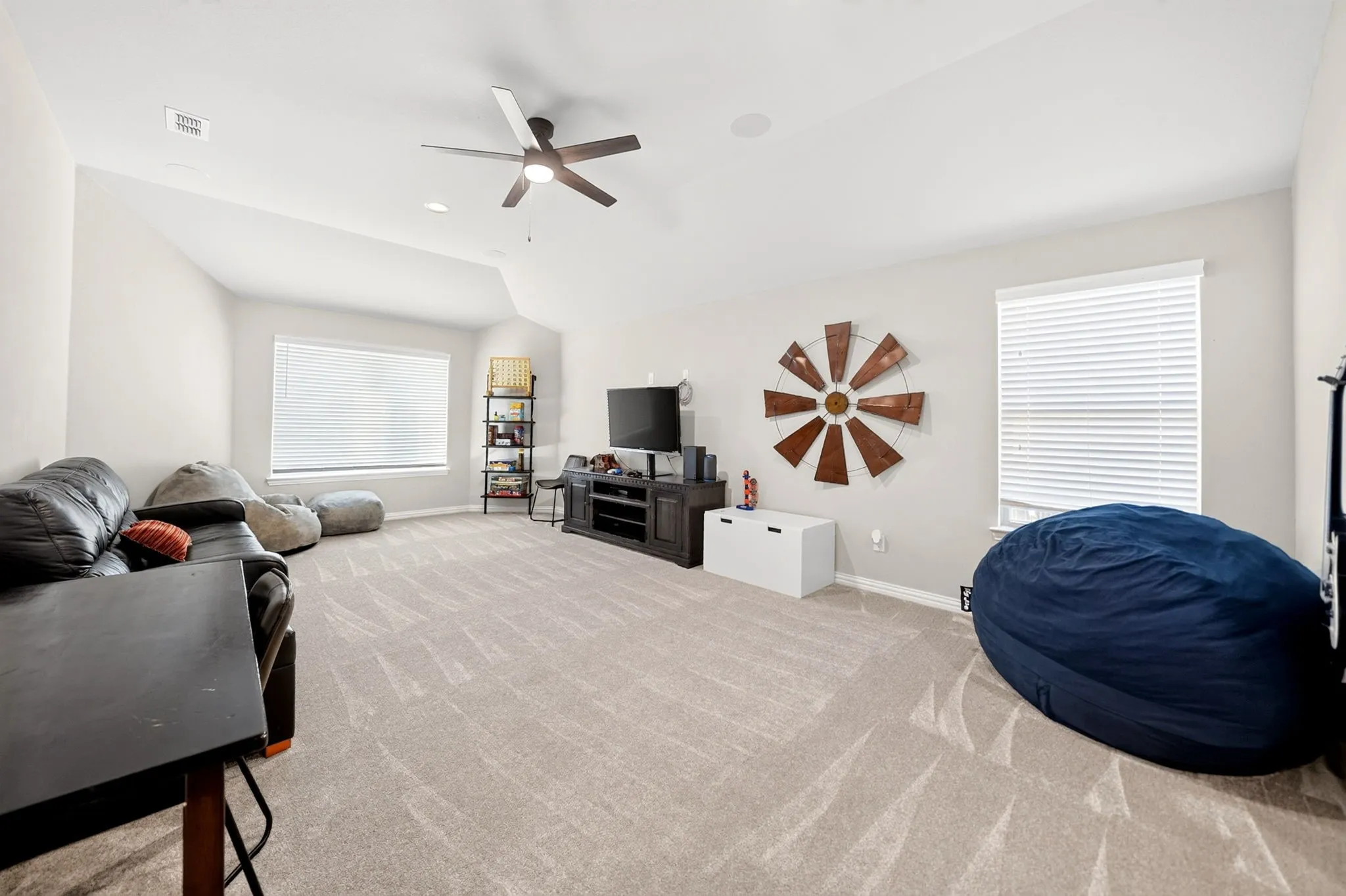 Spacious room with sloped ceilings and light neutral wall tones