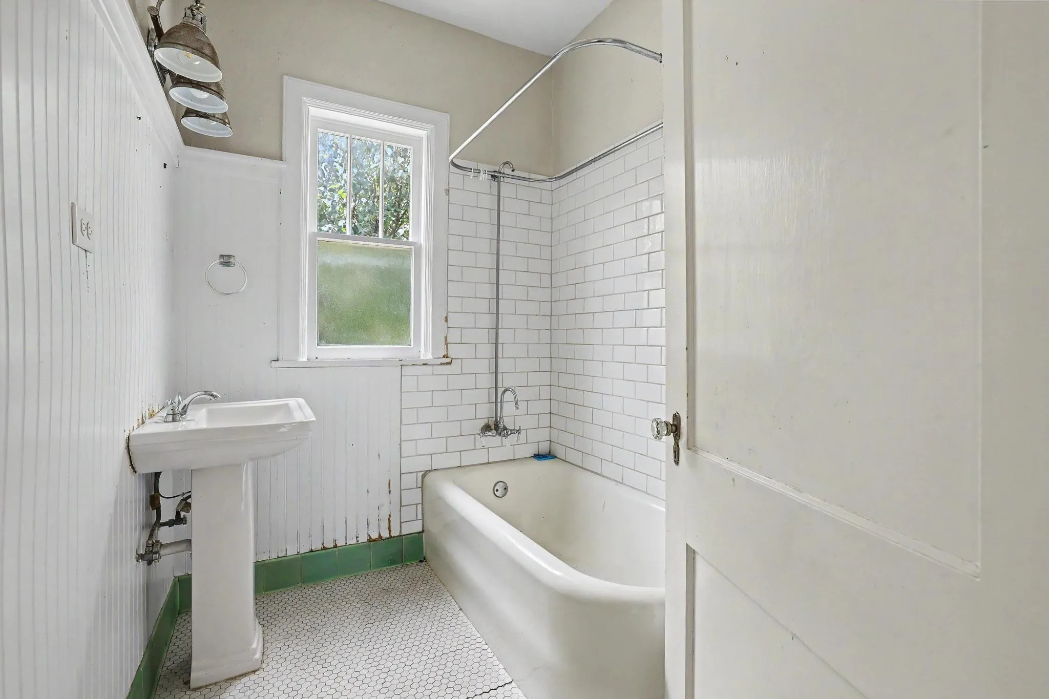 Bathroom featuring a pedestal sink, subway tile shower surround, and hexagonal floor tiles