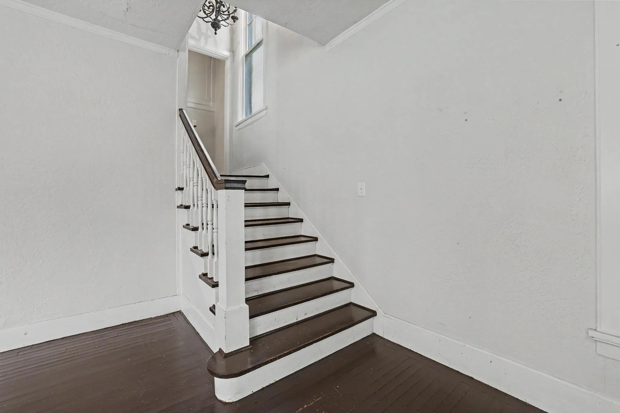 Staircase with dark wood treads and a white spindle railing