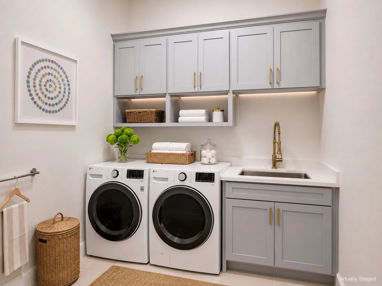 Dedicated laundry space featuring light grey cabinetry with gold-tone hardware, built-in shelving, under-cabinet lighting, and a utility sink with a gold-tone faucet