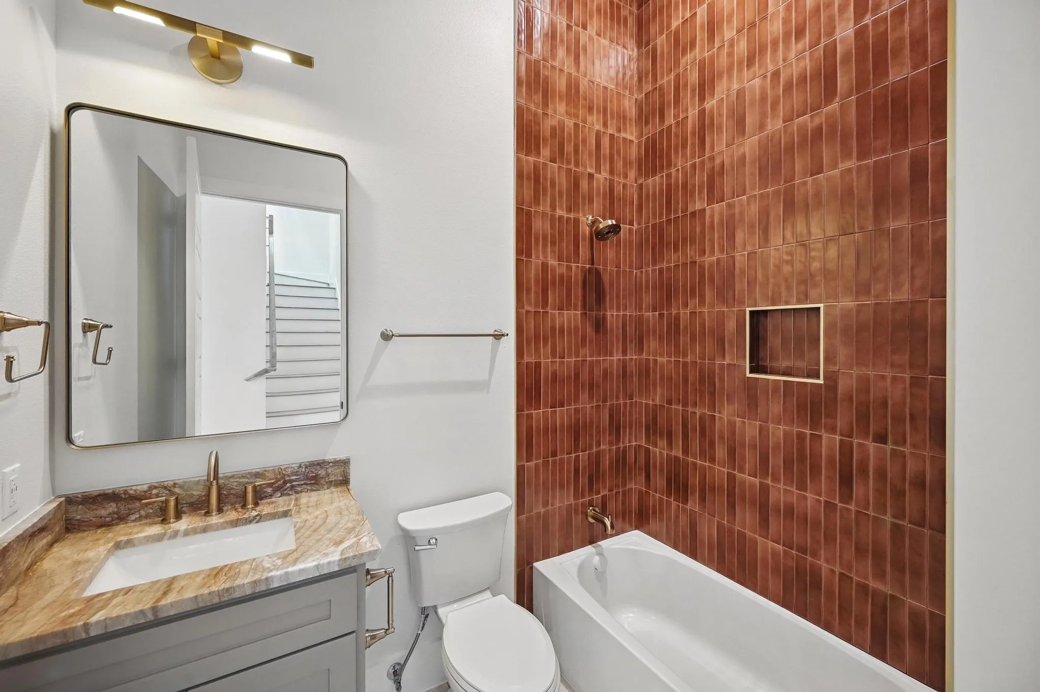 Bathroom featuring a vanity with a stone countertop, an undermount sink, and a gold-toned faucet