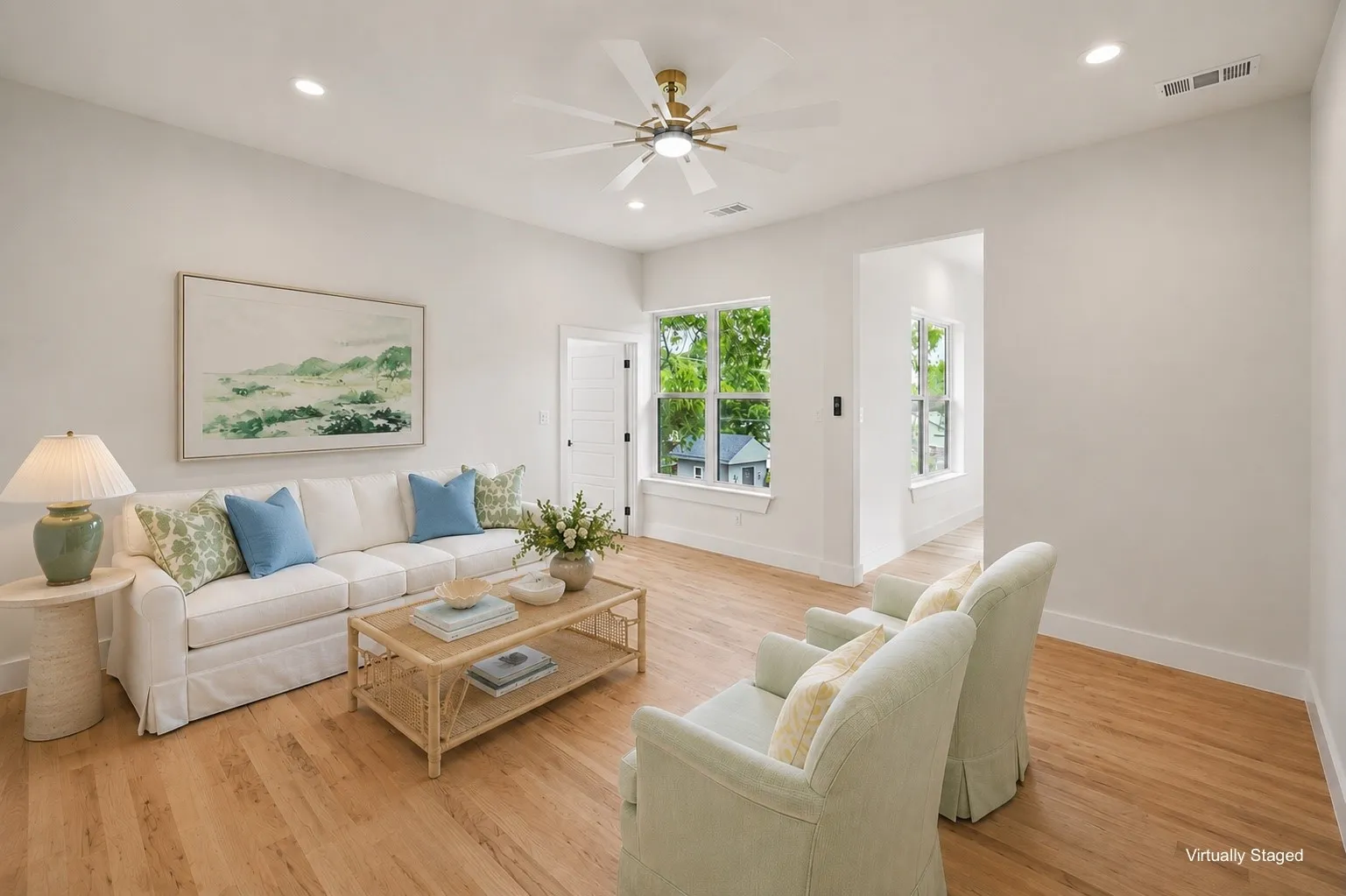 Bright living area featuring wood-finish flooring, recessed lighting, and a ceiling fan