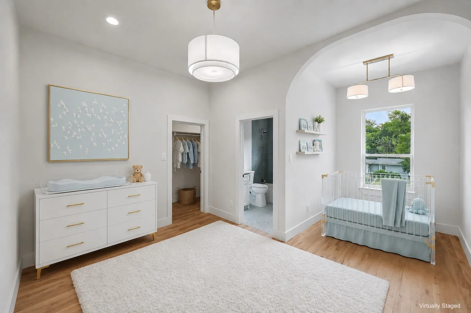 Bright interior room featuring wood-finish flooring, a built-in closet, and an arched doorway leading to an additional space