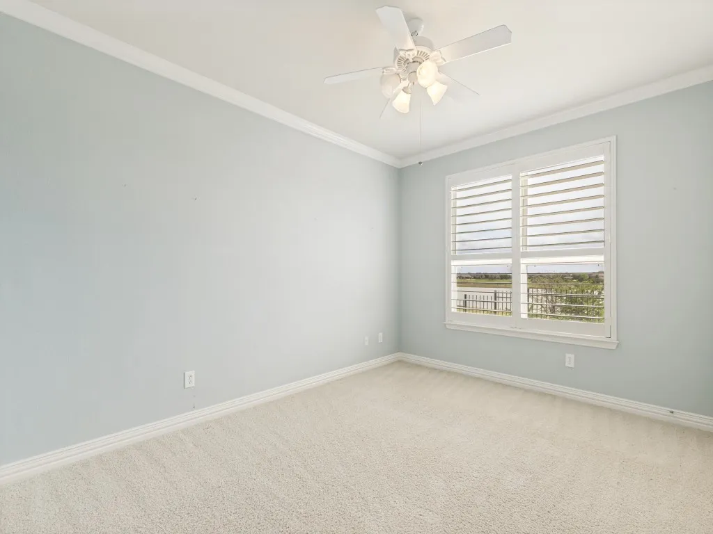 Double-pane window with white plantation shutters, offering an exterior water view