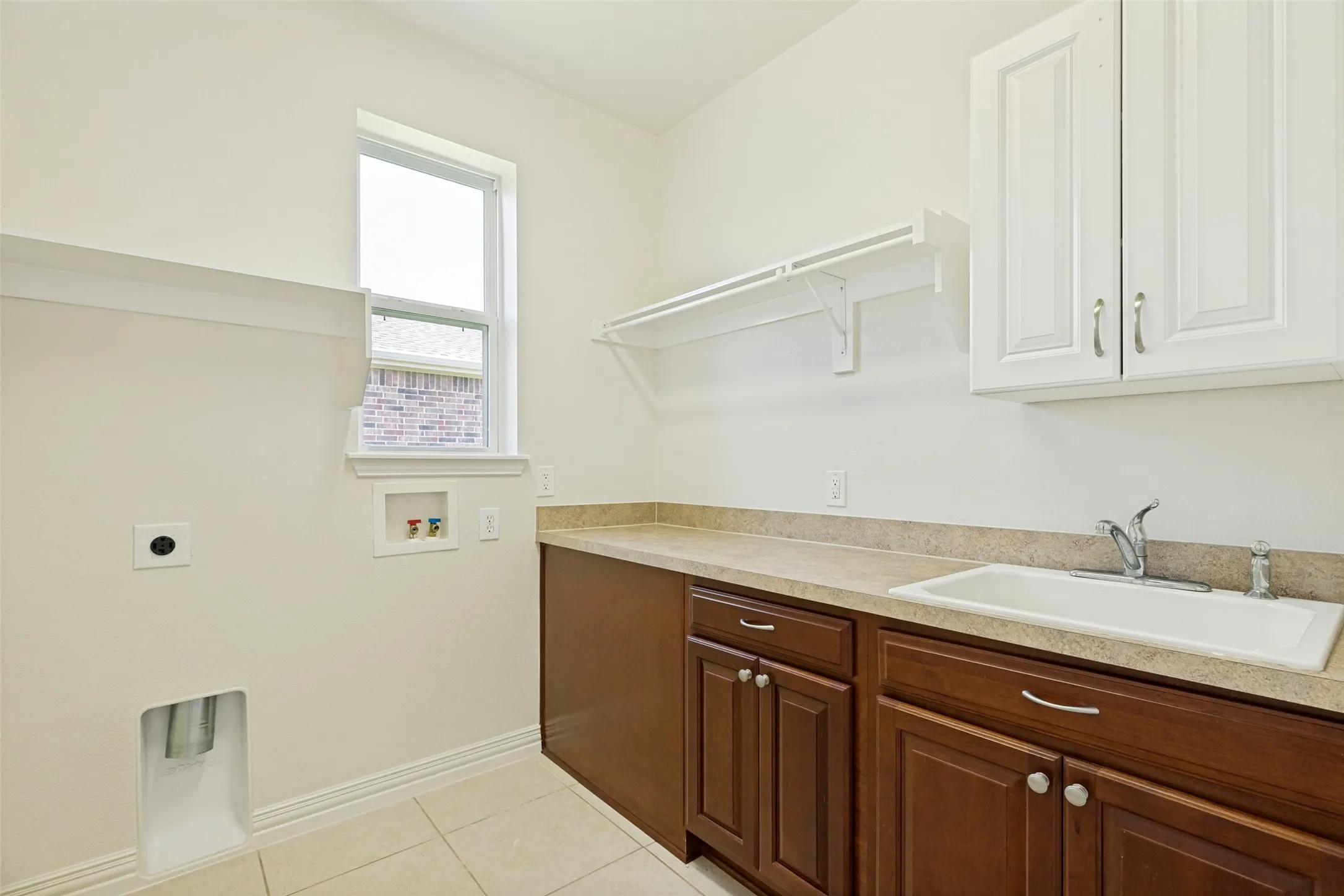 Centrally Located Laundry Center with convenient sink, counter space and cabinetry.