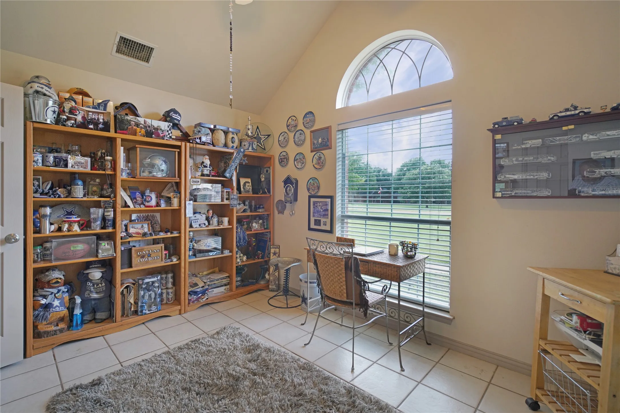Room with vaulted ceiling and tiled flooring
