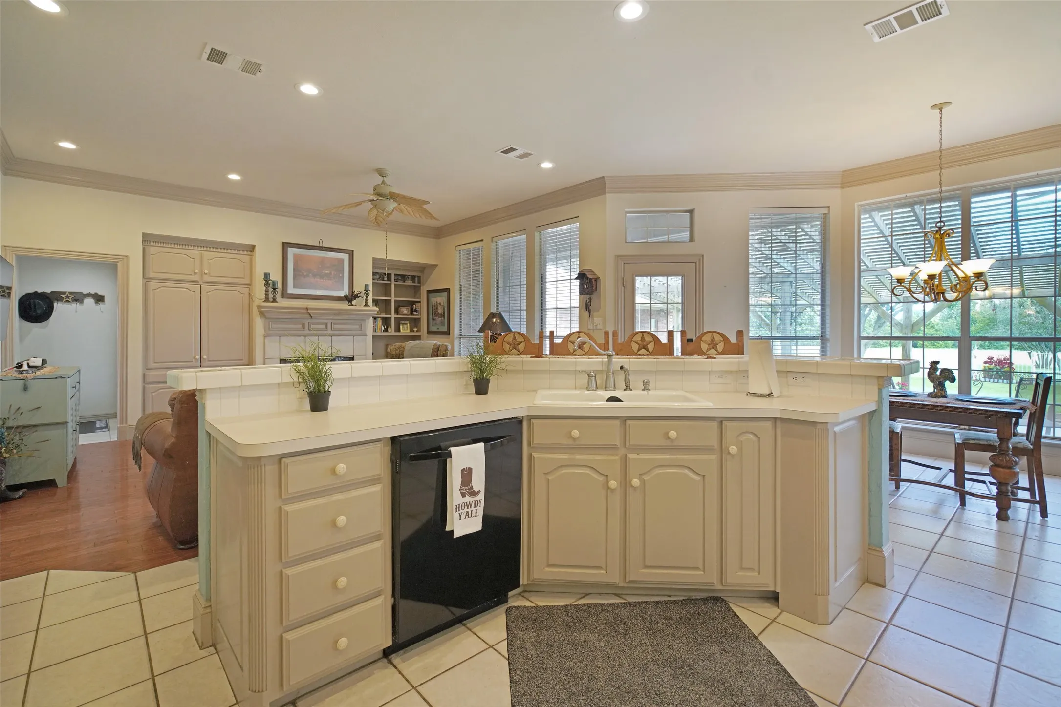 Kitchen featuring a built-in dishwasher, ample cabinetry, a double basin sink, and tile flooring