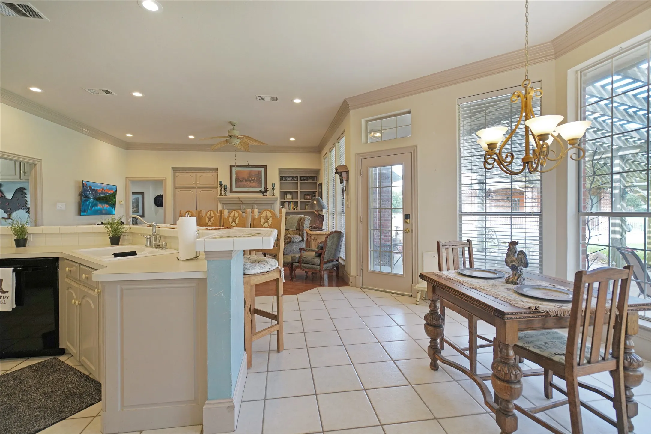 Kitchen and dining area featuring tile flooring, white cabinetry, recessed lighting, and a chandelier over the dining space