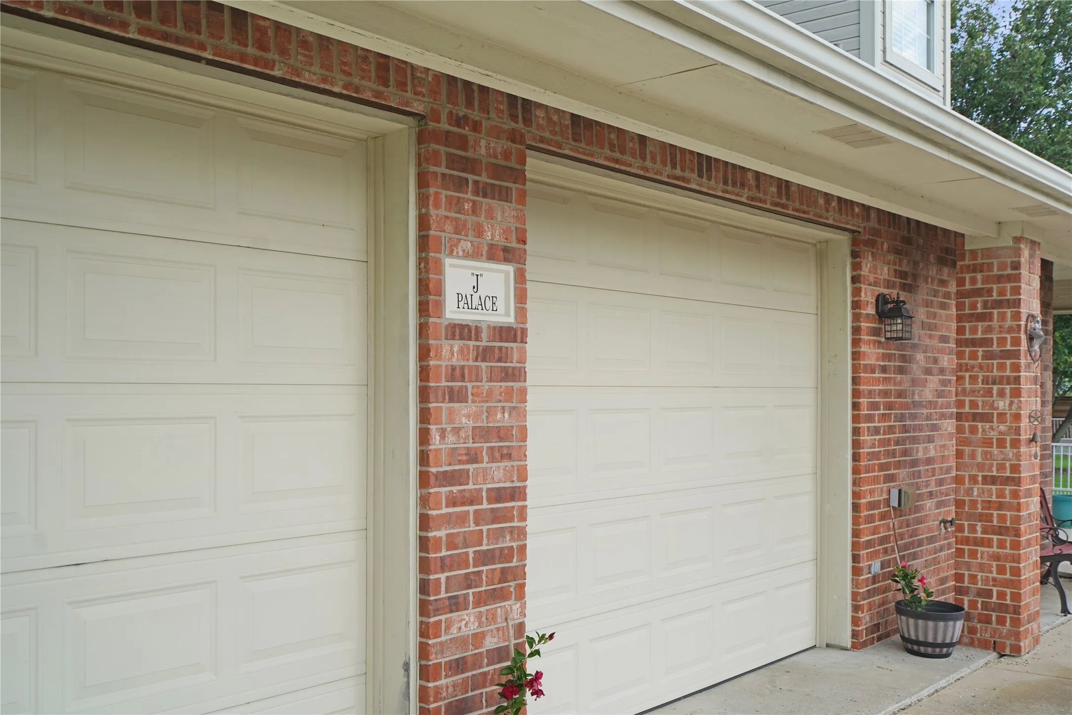 Two panel-style garage doors set within a brick facade