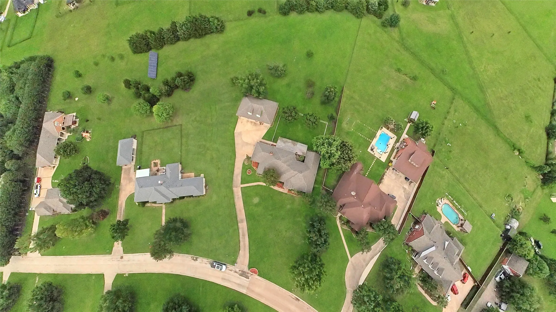 Aerial view showcasing multiple residential properties with expansive green spaces