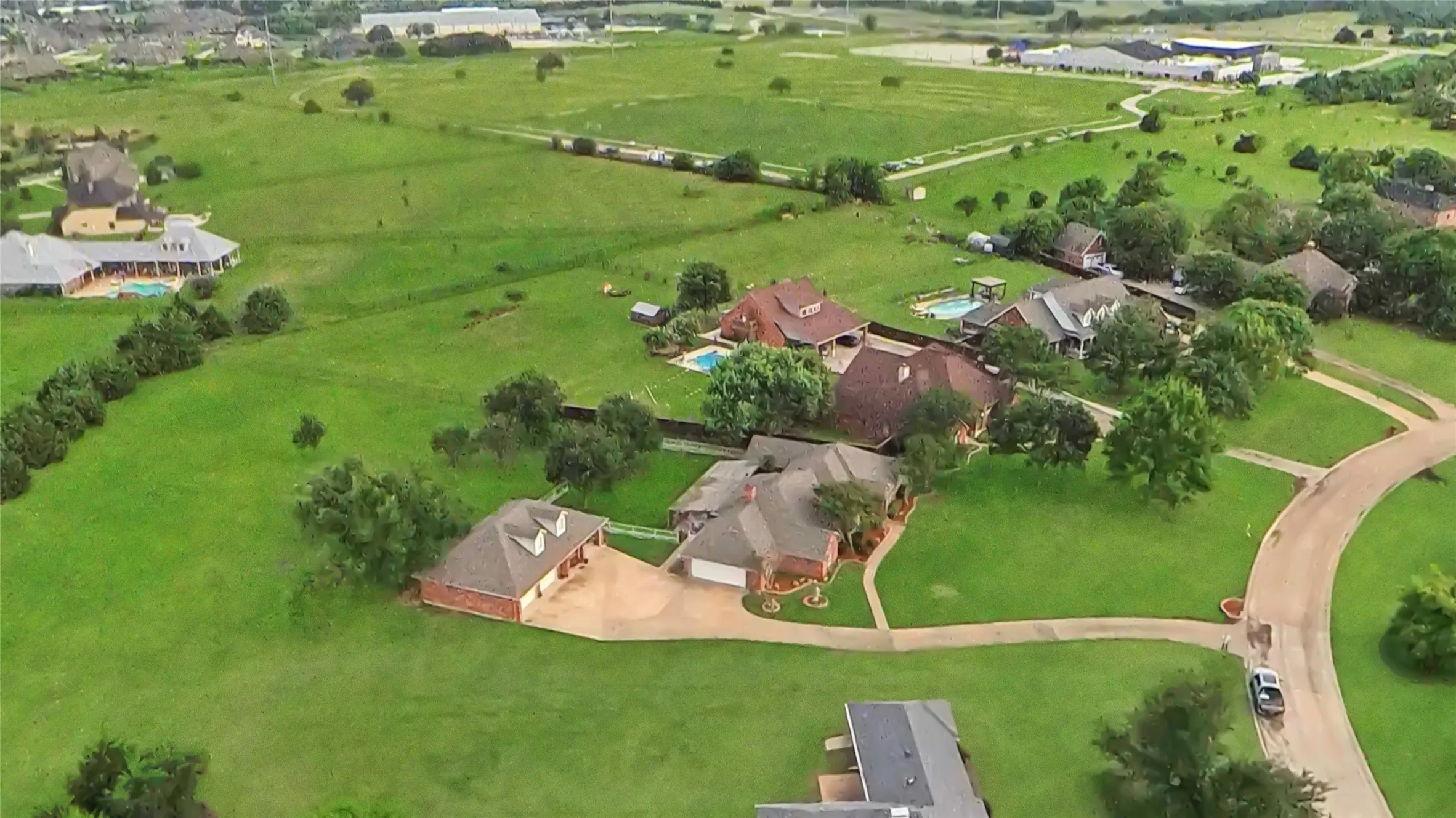 Aerial overview of properties featuring expansive green spaces