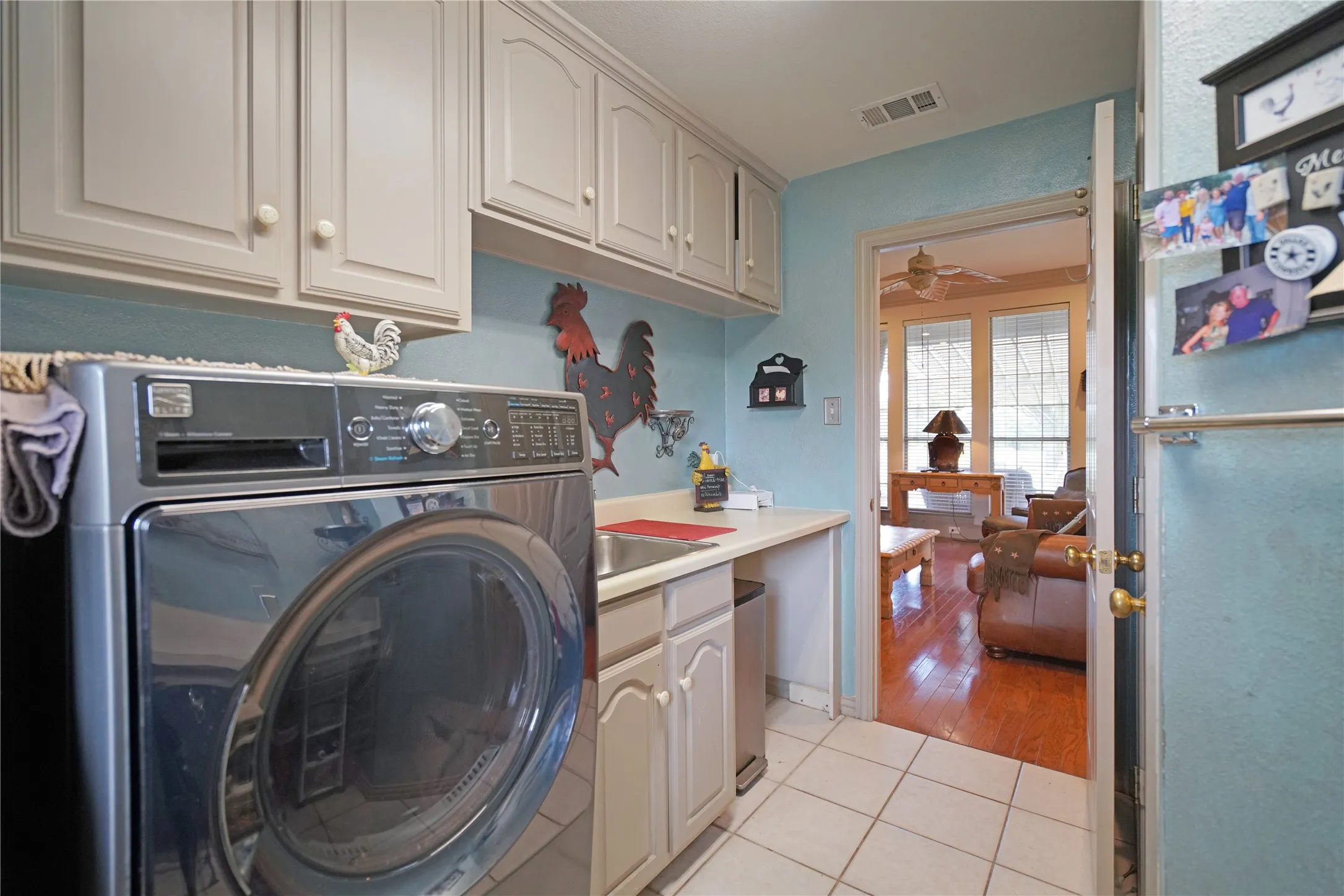 Utility area with light-colored cabinetry, a built-in sink, and a white countertop