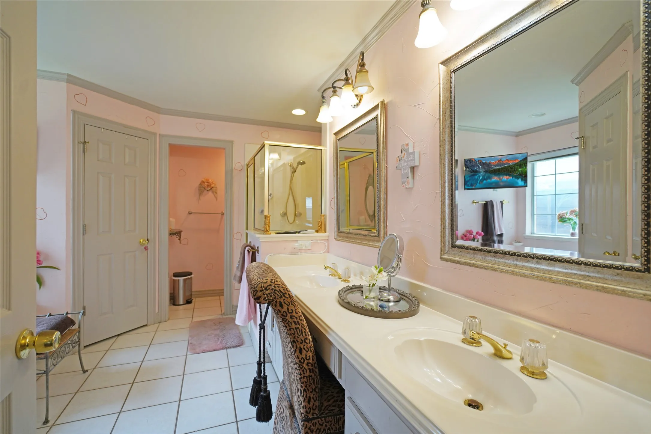 Double vanity featuring white countertops and ornate gold-tone fixtures