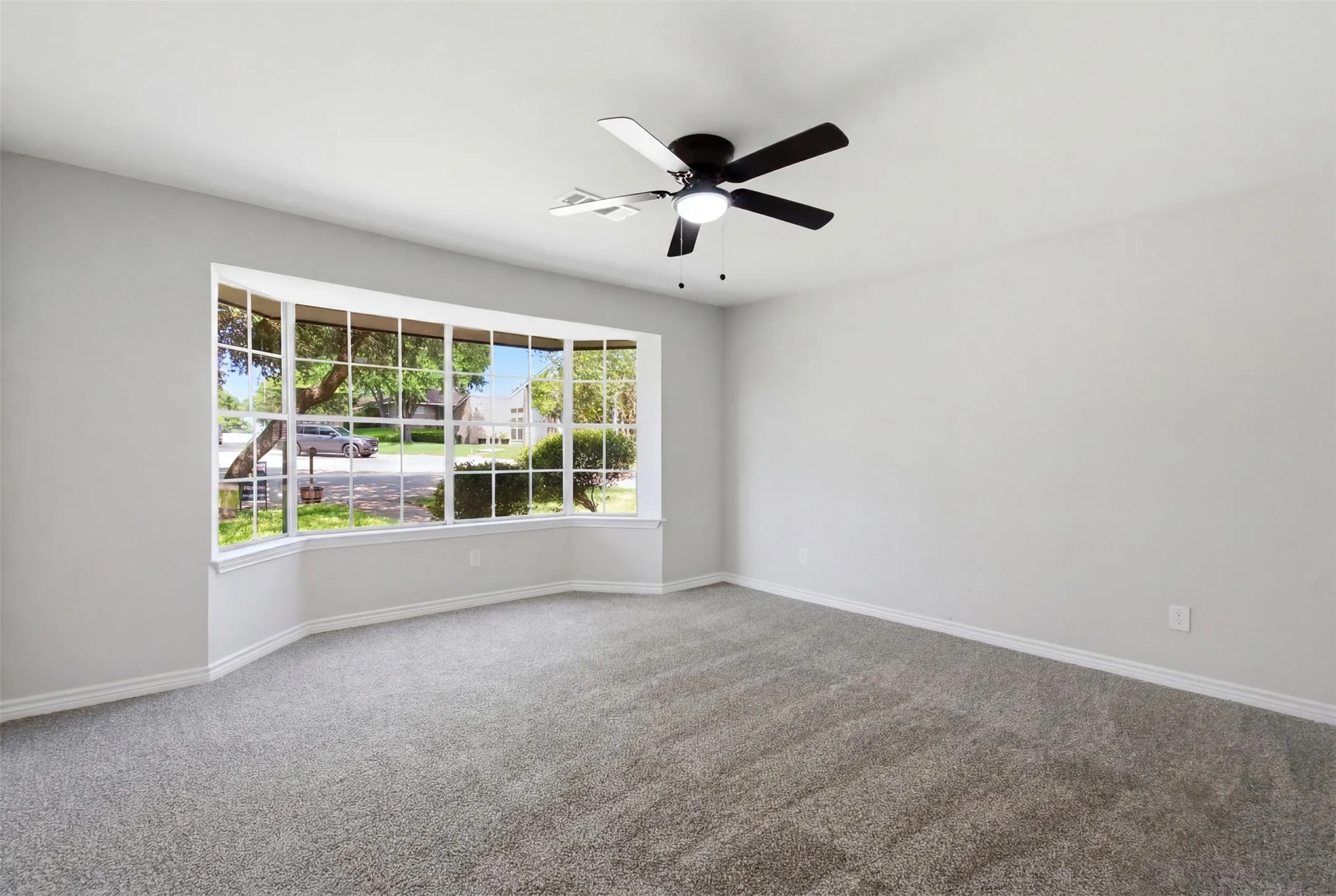 Spacious room featuring a wide bay window with multiple panes, providing substantial natural light