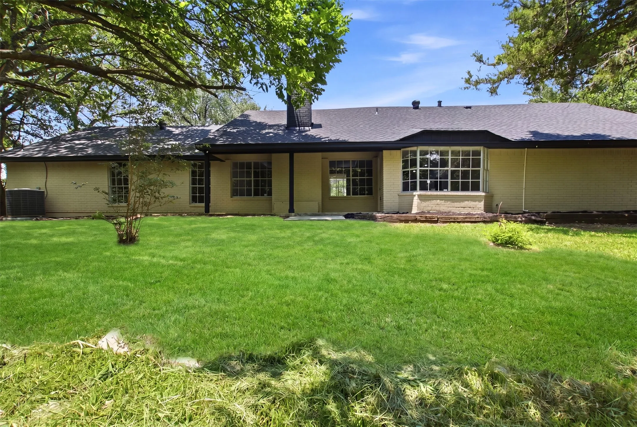 Expansive green lawn bordering the rear elevation