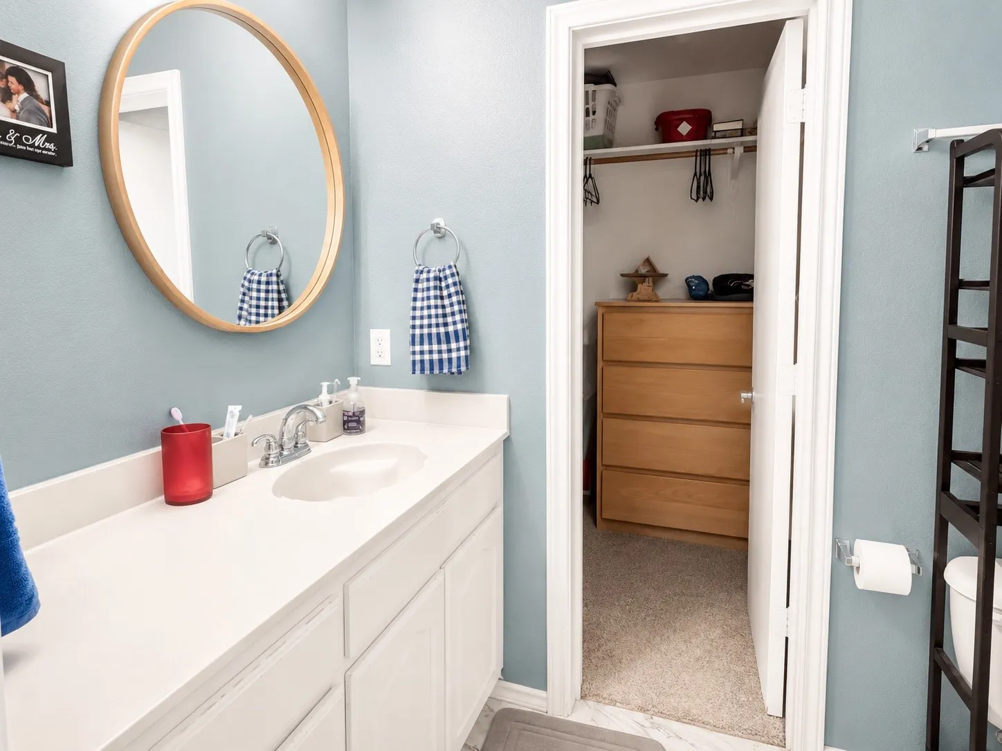 Bathroom vanity featuring an integrated sink, white cabinetry, and a full-width countertop