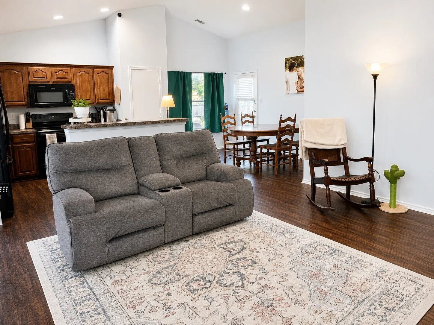 Open concept living area featuring vaulted ceilings, wood-finish flooring, and recessed lighting