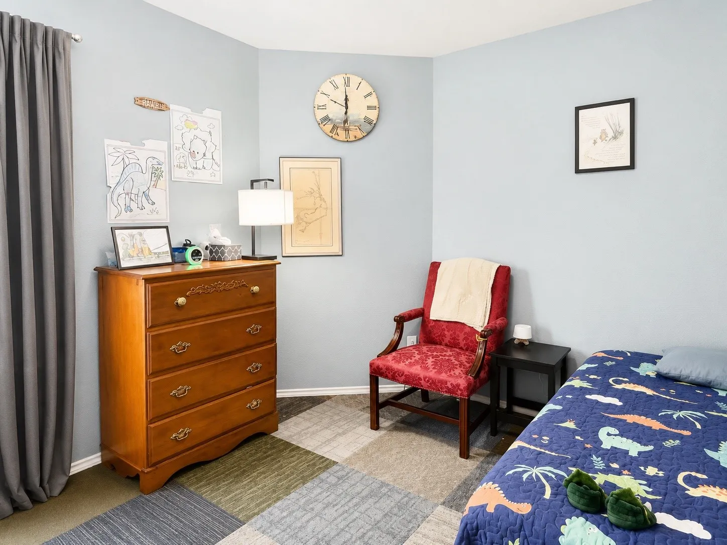 Light blue painted walls provide a calm backdrop for the room's multi-toned square pattern carpet