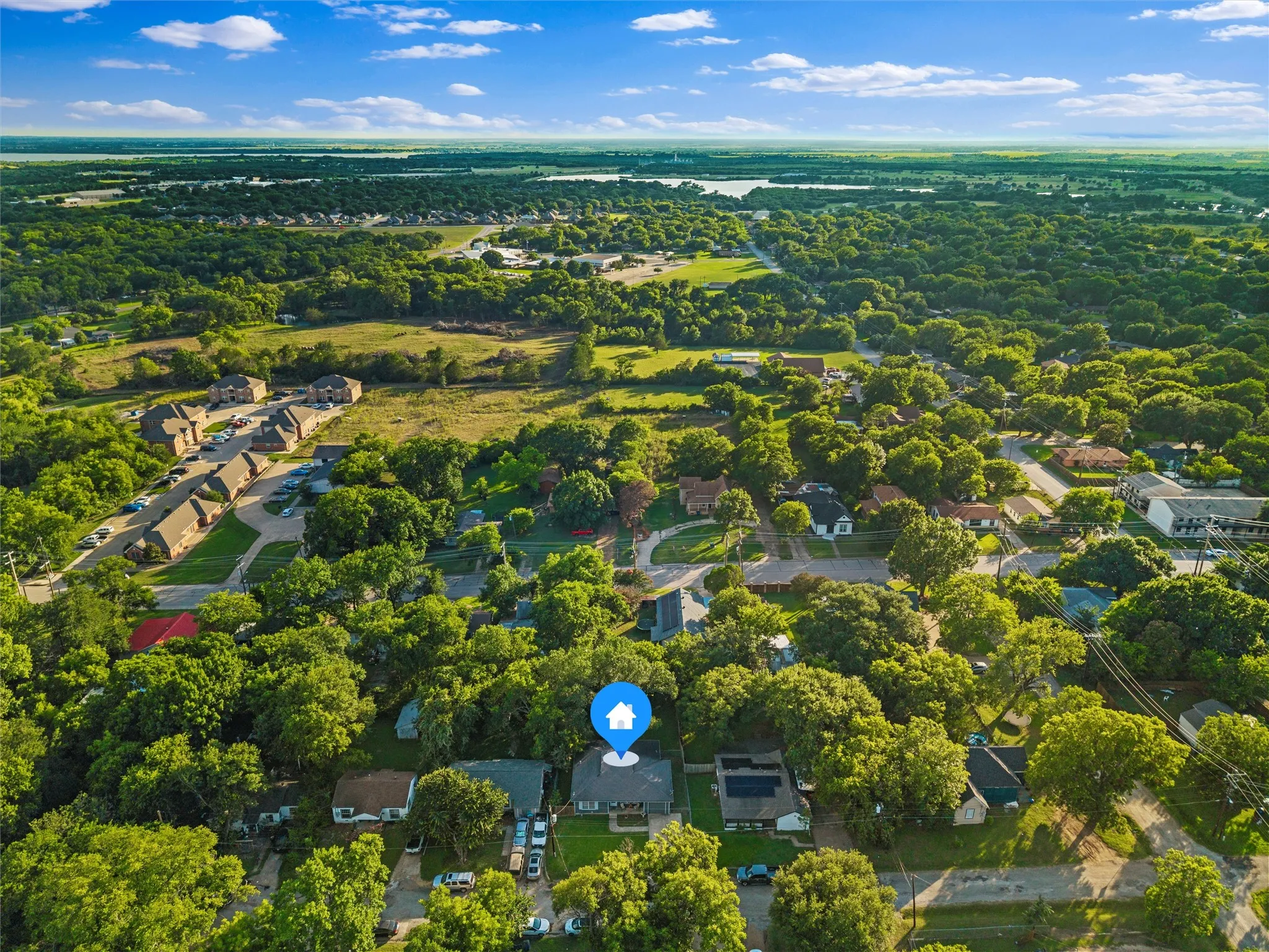 Aerial view highlights the surrounding neighborhood and nearby homes.