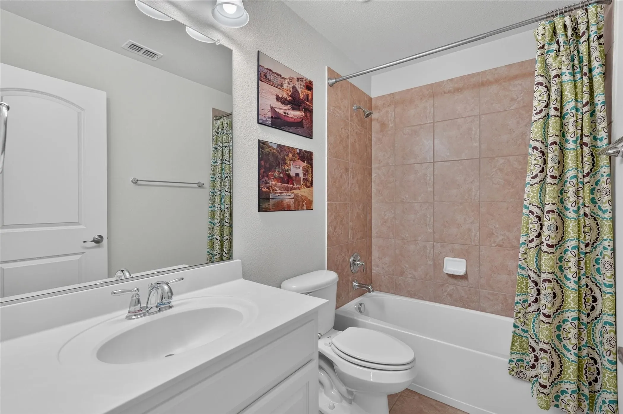 Bathroom featuring a white vanity with an integrated sink, polished chrome faucet, full-width mirror, and overhead track lighting
