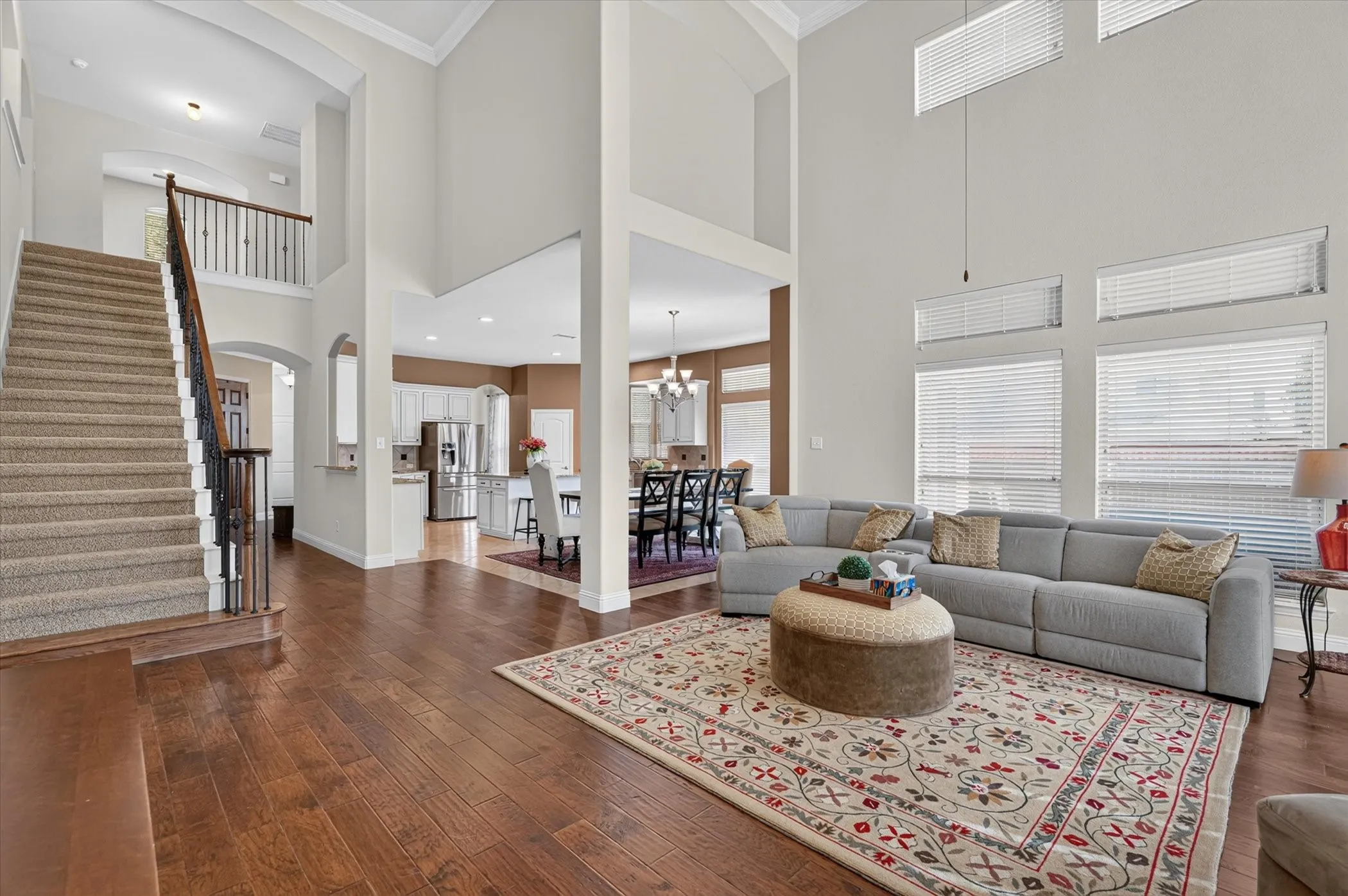 Two-story living area featuring wood-finish flooring and high ceilings