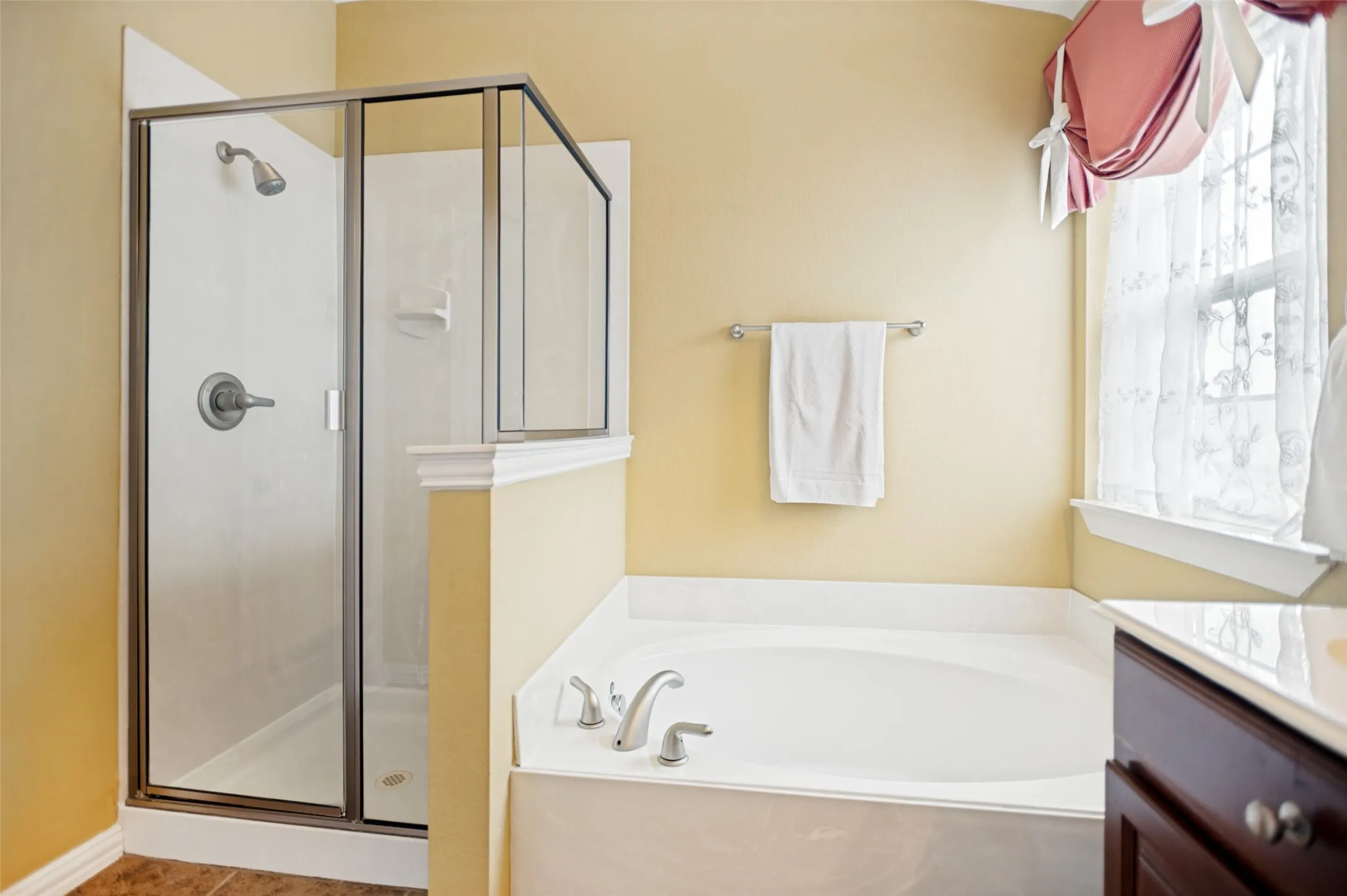 Bathroom featuring a separate walk-in shower with clear glass enclosure and a built-in soaking tub with deck-mounted fixtures