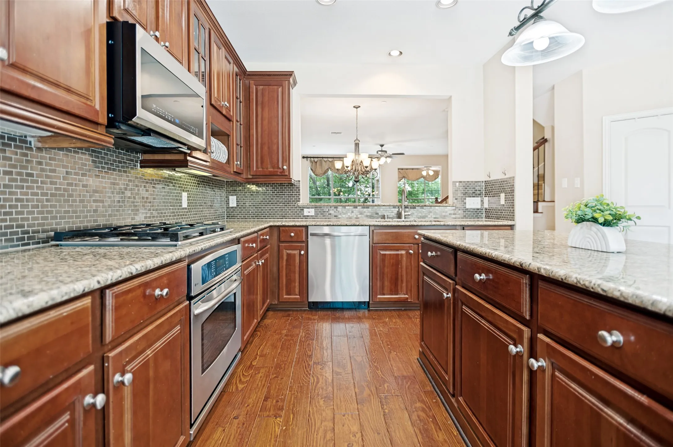 Well-appointed kitchen featuring rich wood cabinetry, granite countertops, and stainless steel appliances