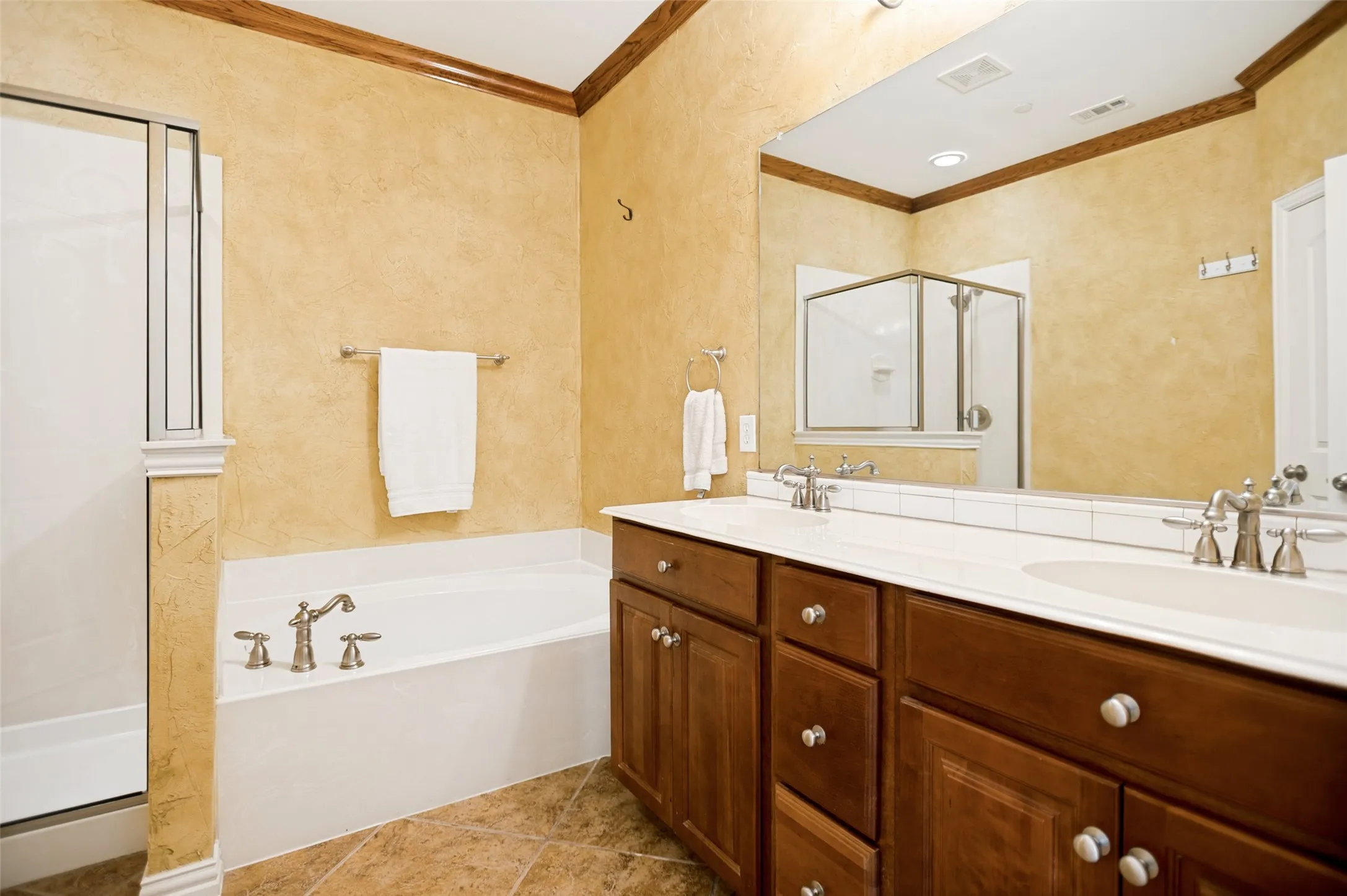 Double vanity with undermount sinks, wood cabinetry, and brushed nickel hardware
