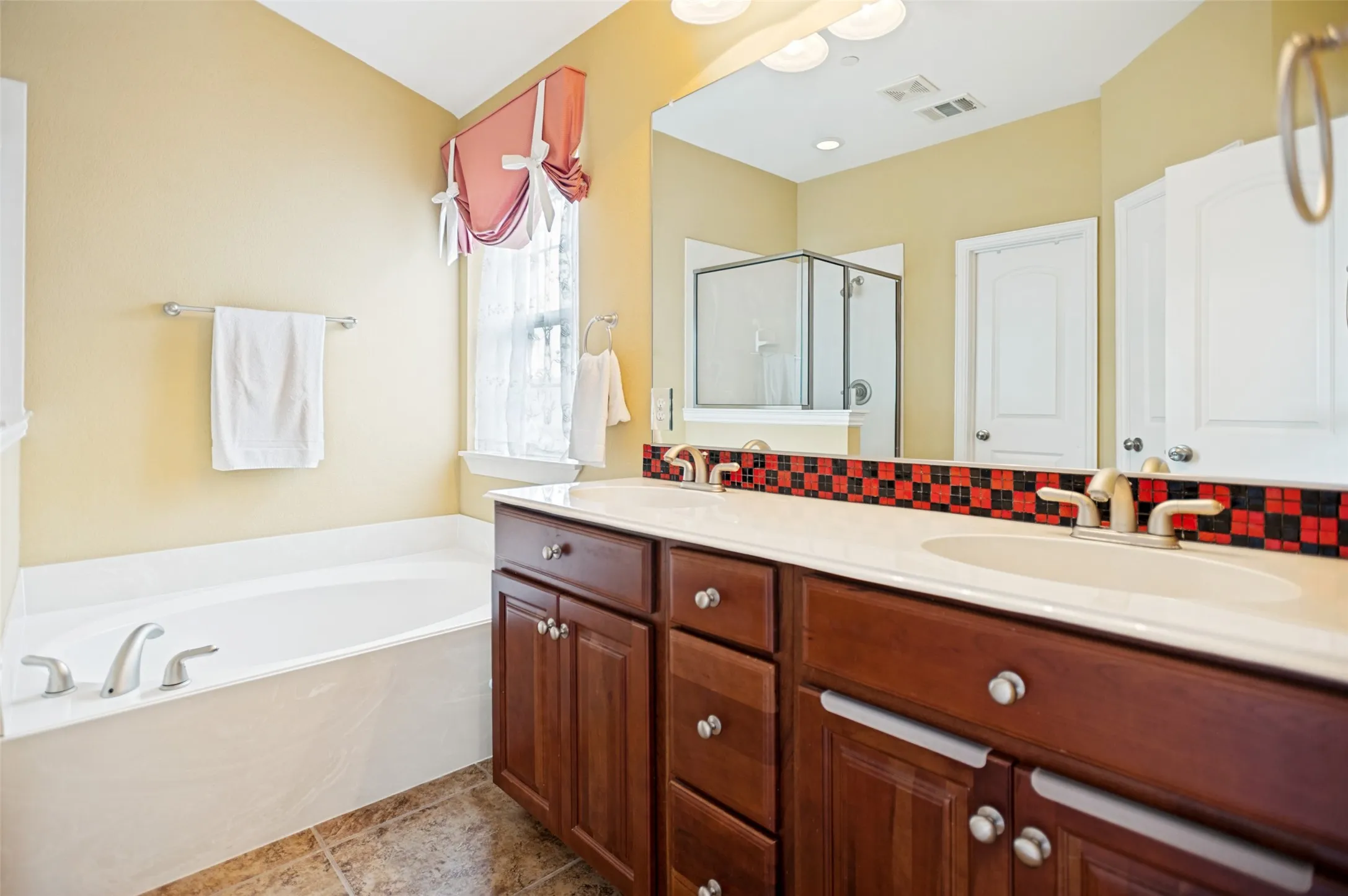 Dual sink vanity with dark wood-finish cabinetry and a light-toned countertop