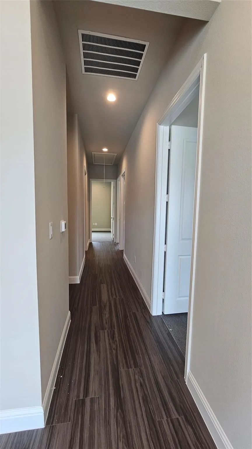 Hallway with wood-finish flooring, recessed lighting, and neutral wall tones