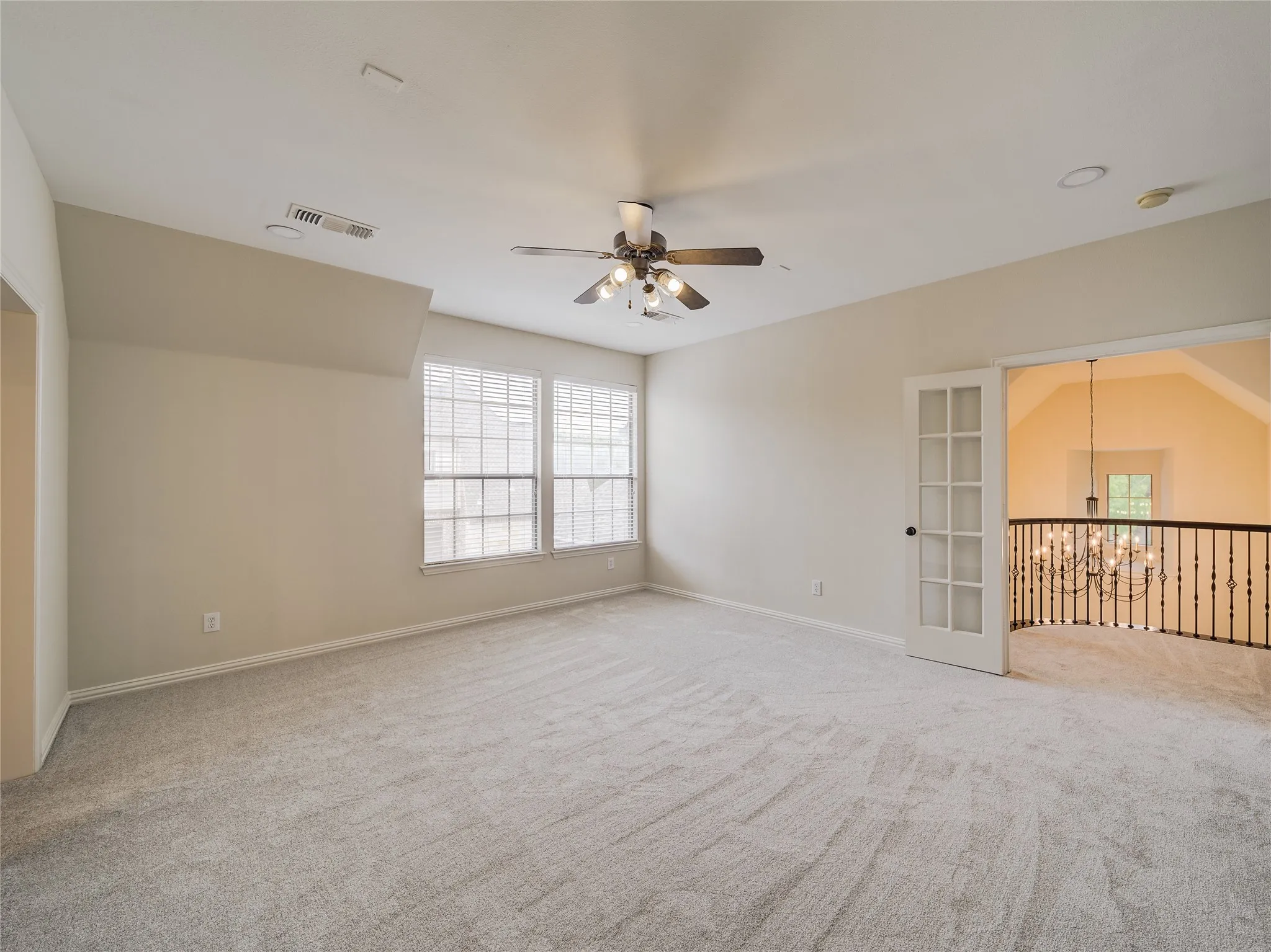 Carpeted room with a ceiling fan, recessed lighting, and two windows with blinds
